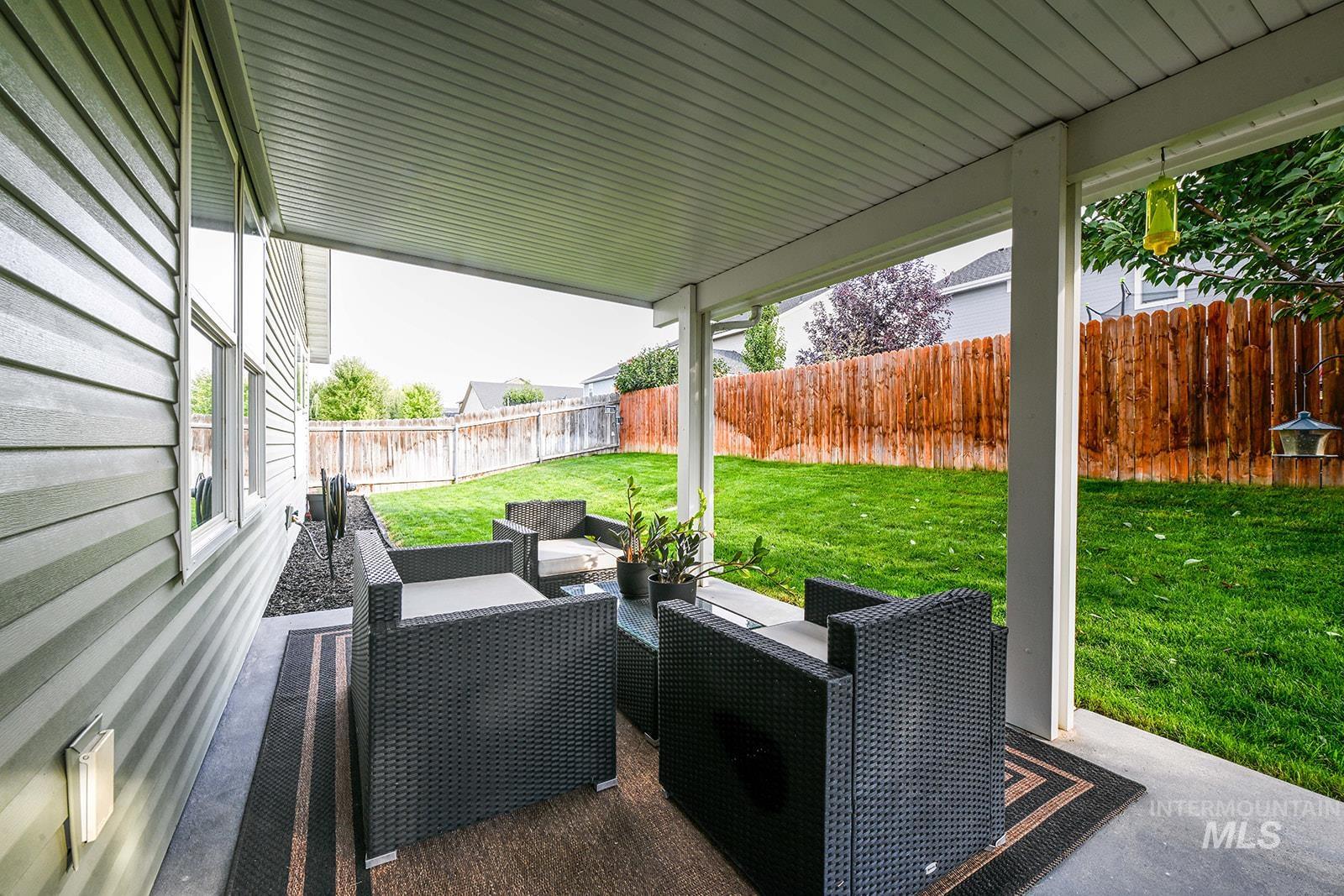 Fenced backyard featuring an outdoor hangout area and a patio