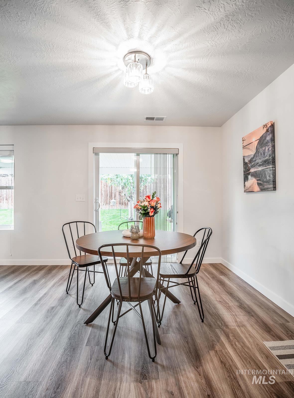 Dining room with a textured ceiling and light wood finished floors