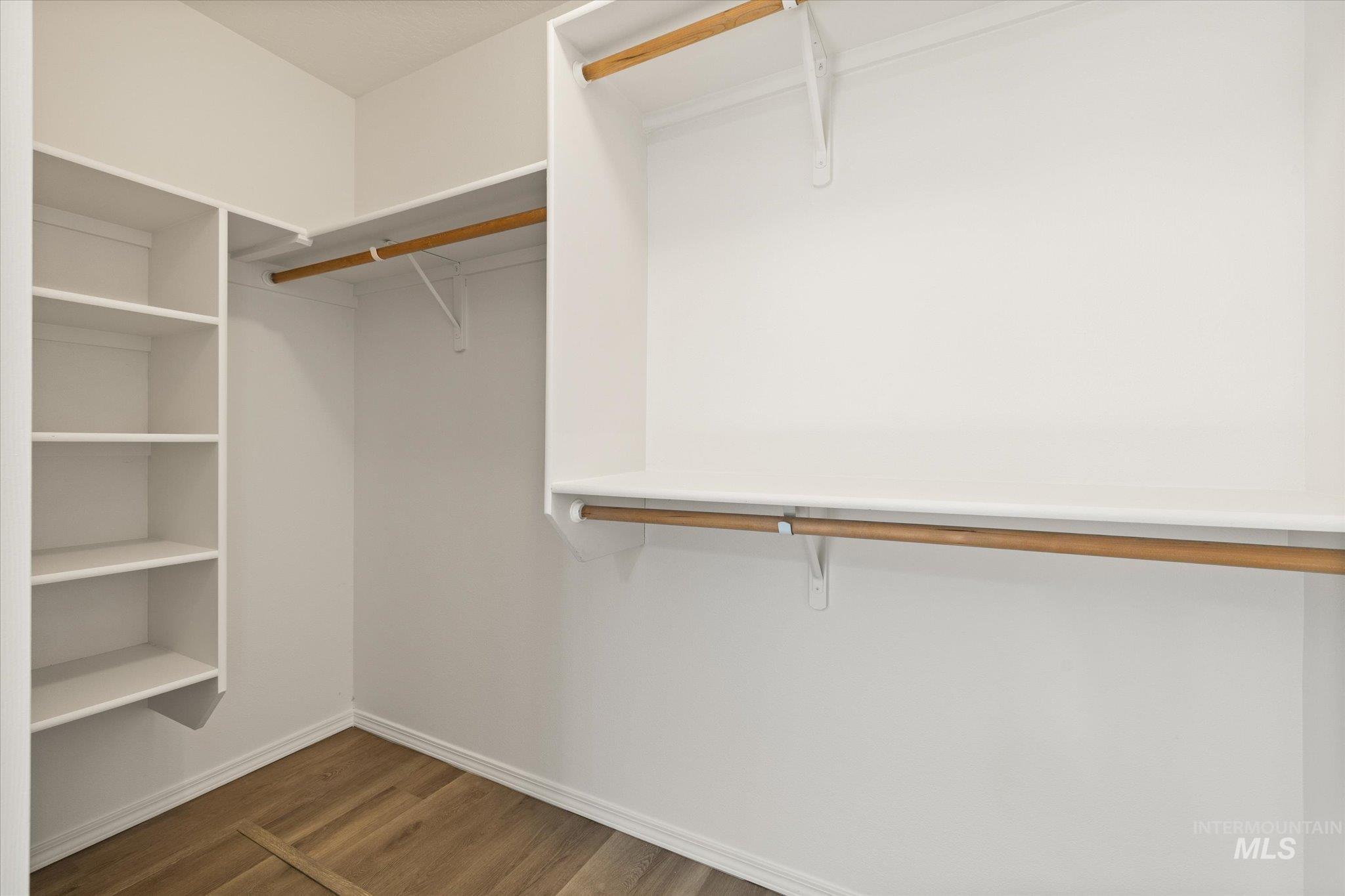 Spacious closet with dark wood-style floors