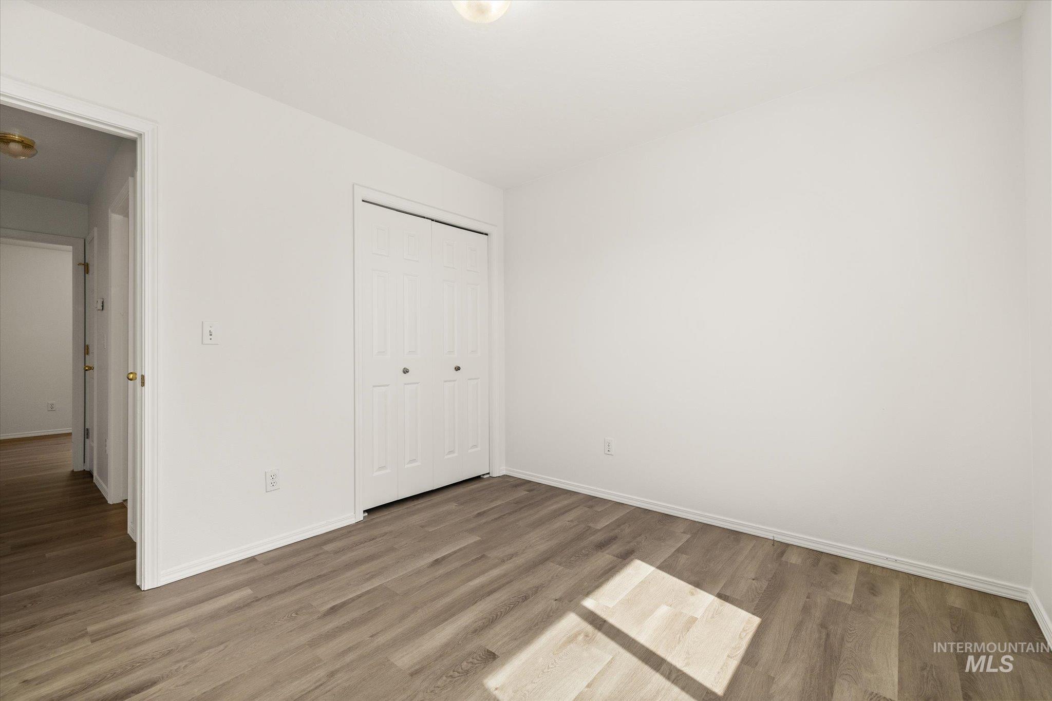 Unfurnished bedroom with light wood-type flooring and a closet