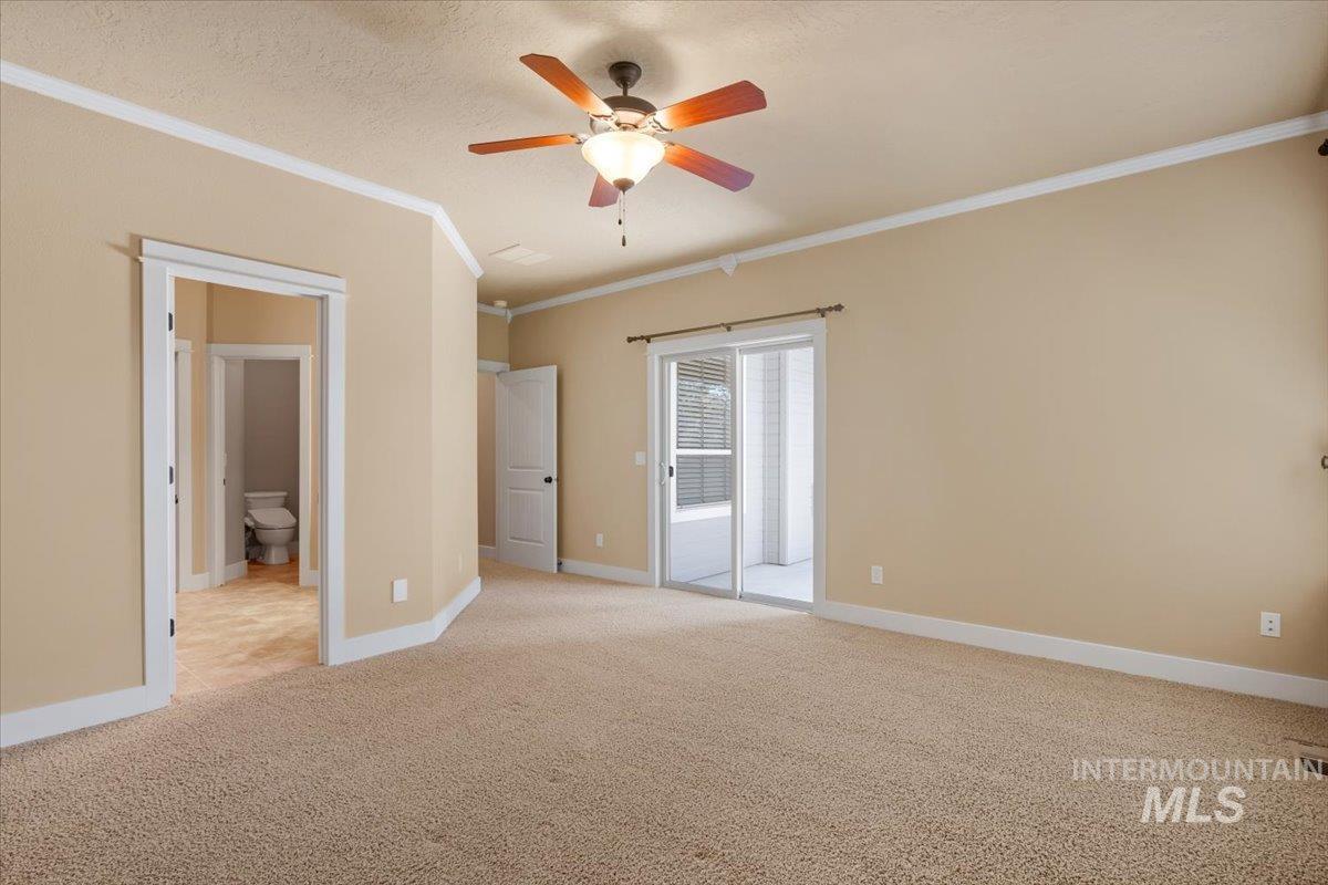 Unfurnished bedroom with ornamental molding, light colored carpet, ceiling fan, access to exterior, and a textured ceiling