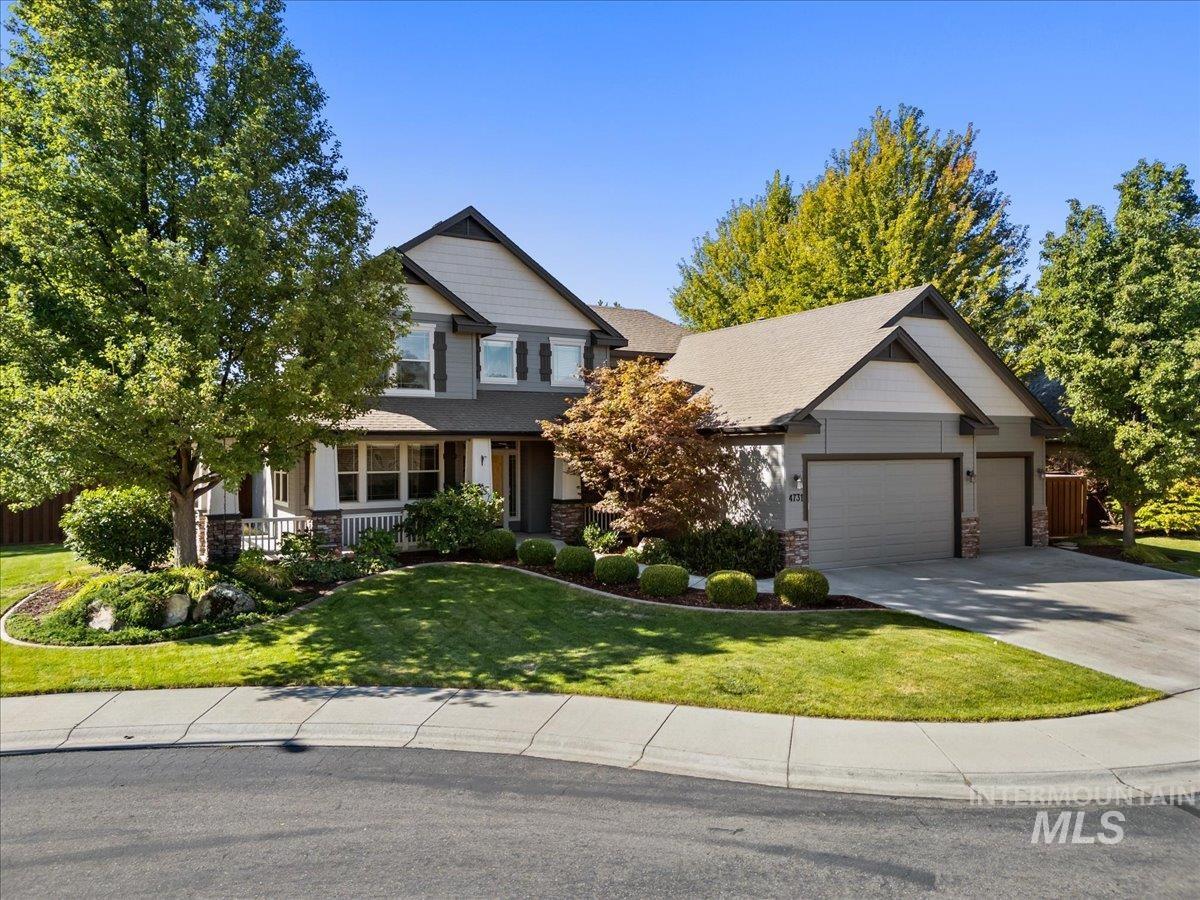Craftsman house with covered porch, stone siding, concrete driveway, a front lawn, and a garage