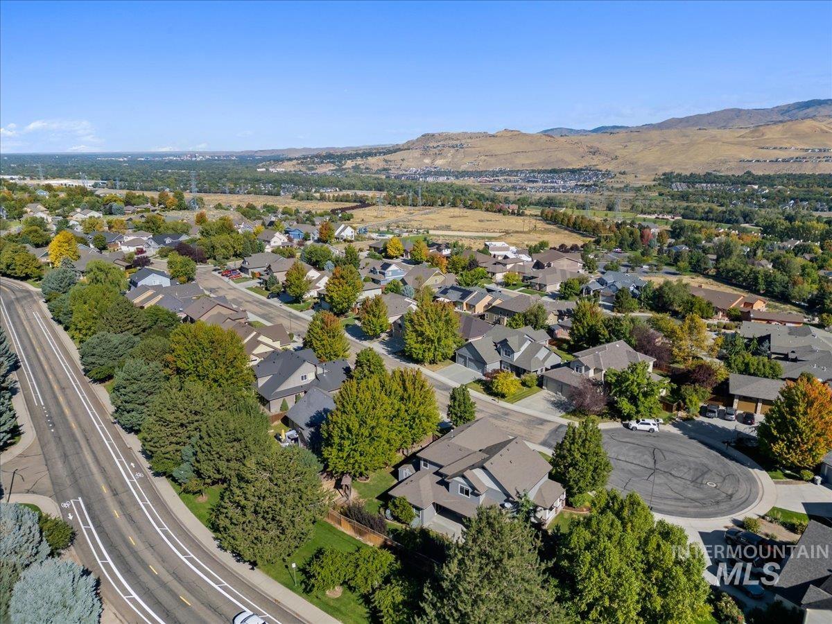 Aerial view of property and surrounding area with nearby suburban area