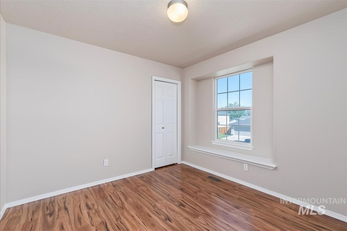 Unfurnished room featuring baseboards and wood finished floors