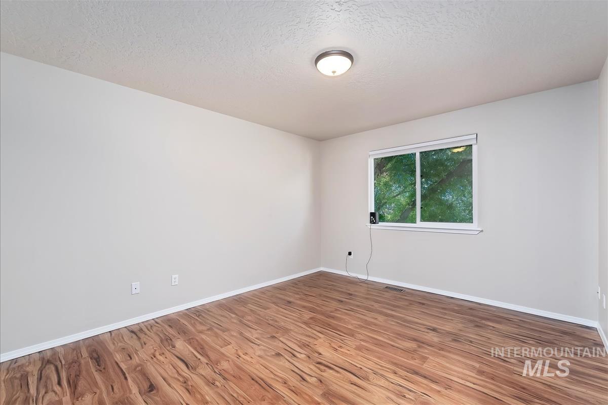 Empty room featuring wood finished floors and a textured ceiling