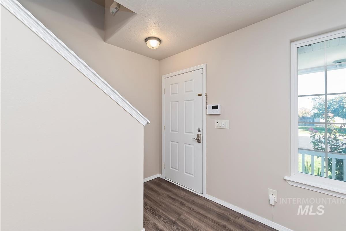 Entryway with baseboards and dark wood-type flooring