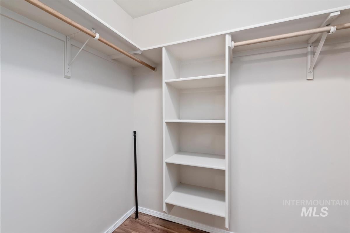 Walk in closet with wood finished floors