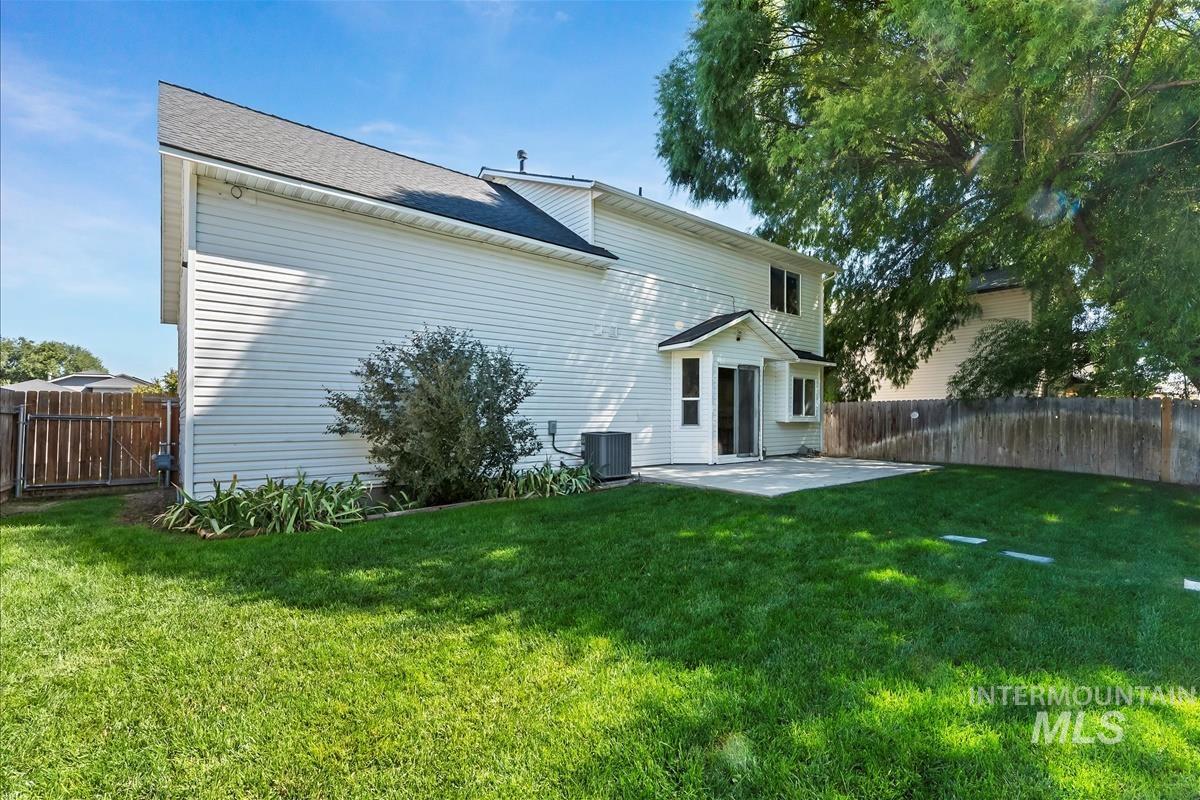 Rear view of property featuring a patio area and roof with shingles