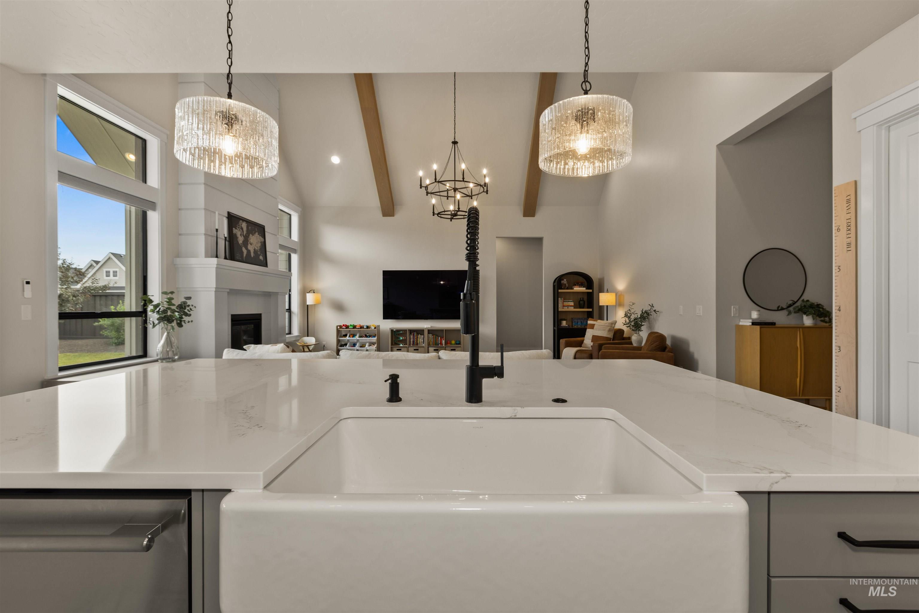 Kitchen with open floor plan, a chandelier, a glass covered fireplace, and decorative light fixtures