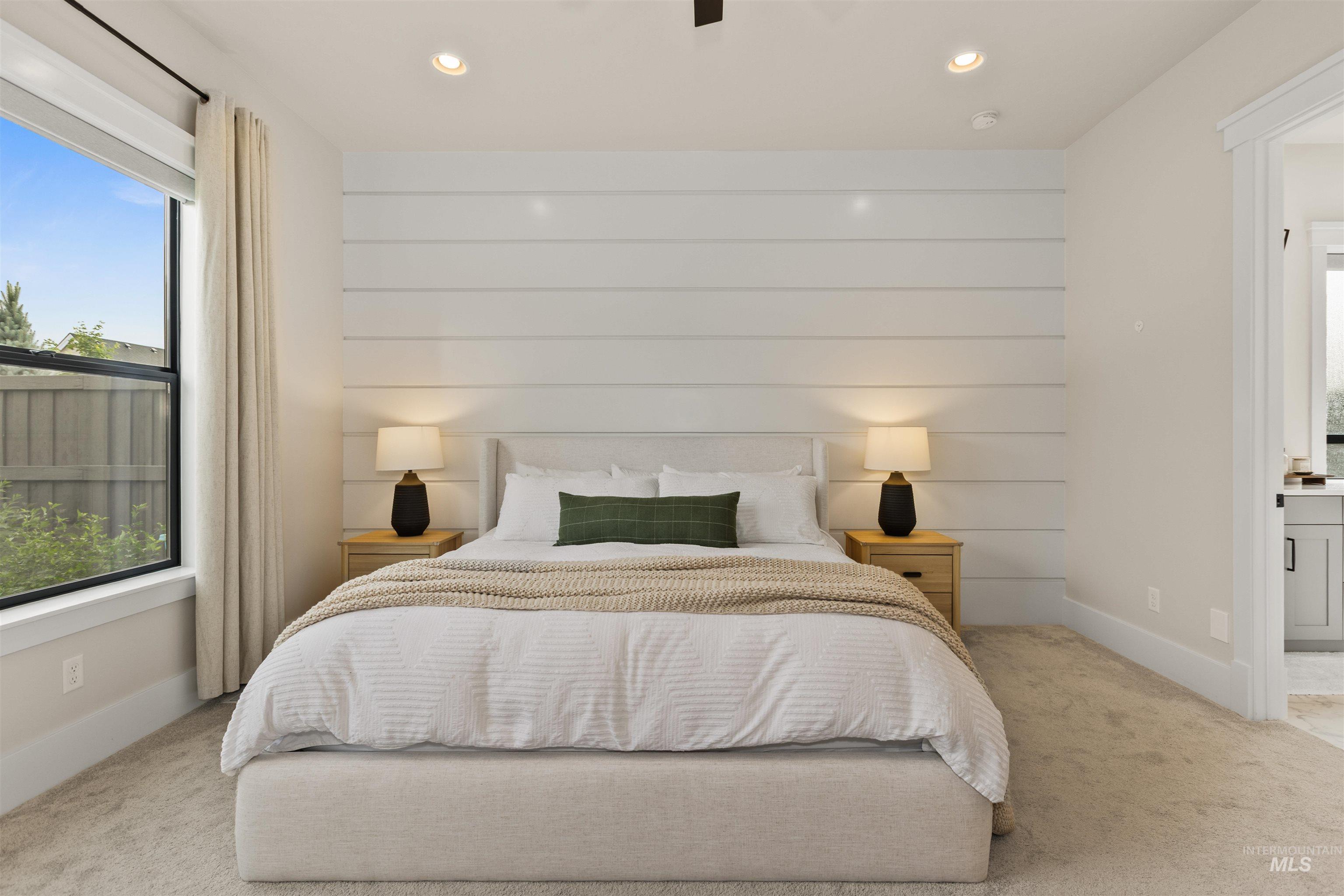 Bedroom with multiple windows, light carpet, recessed lighting, and ensuite bathroom