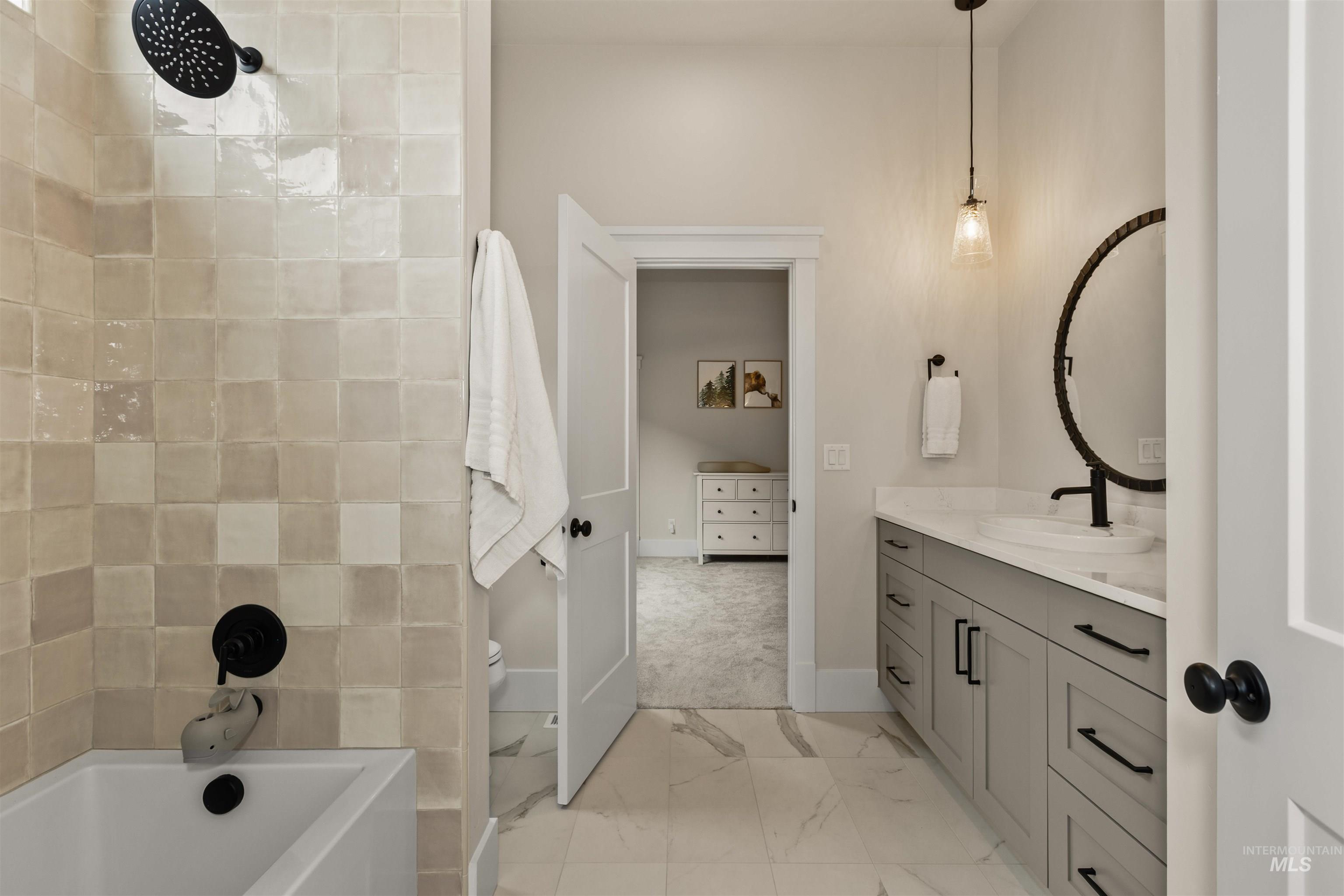 Bathroom with marble look tile flooring, a bath, vanity, and a shower