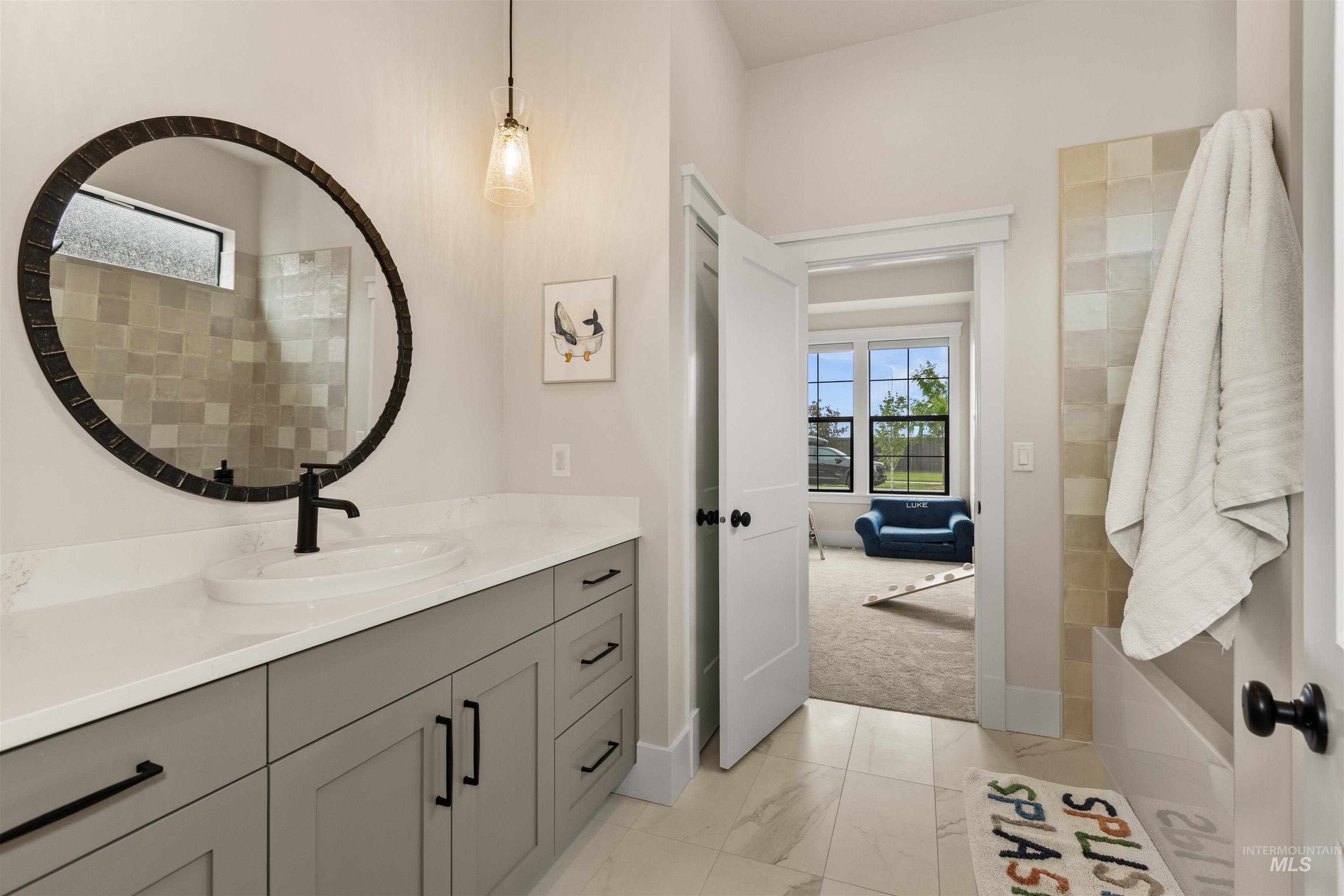 Full bathroom with vanity and marble look tiles