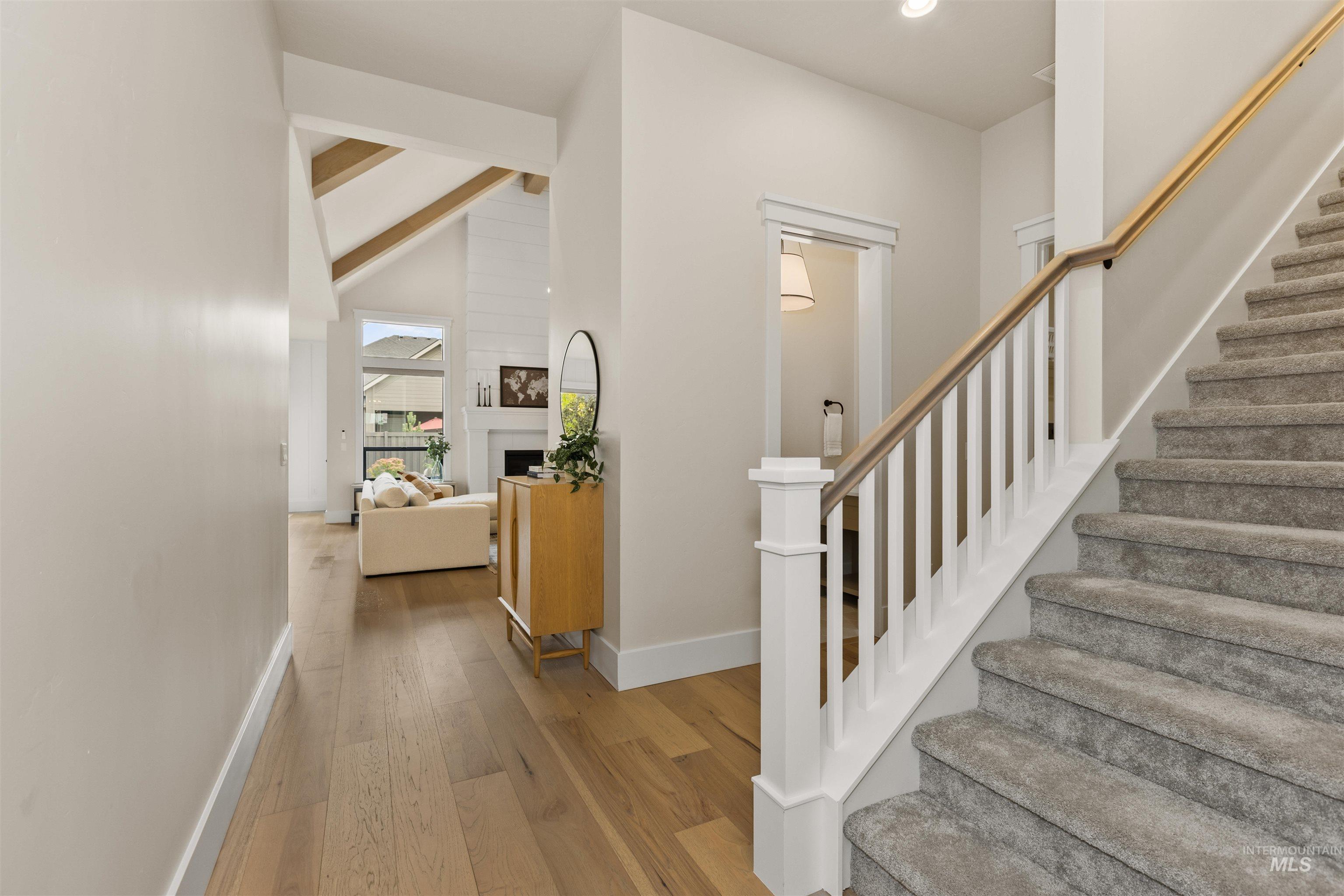 Staircase with wood finished floors and recessed lighting