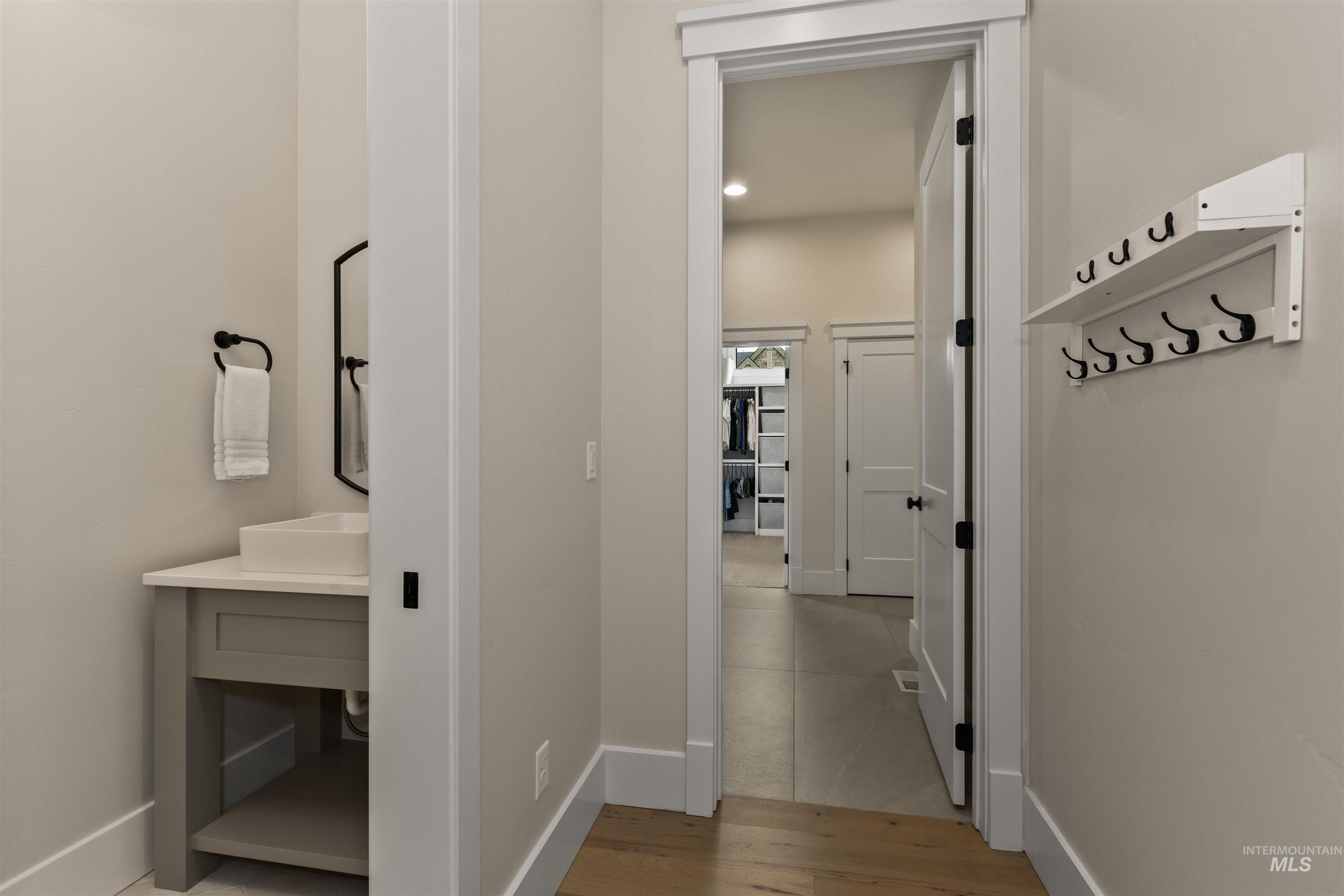 Hall with wood finished floors and recessed lighting