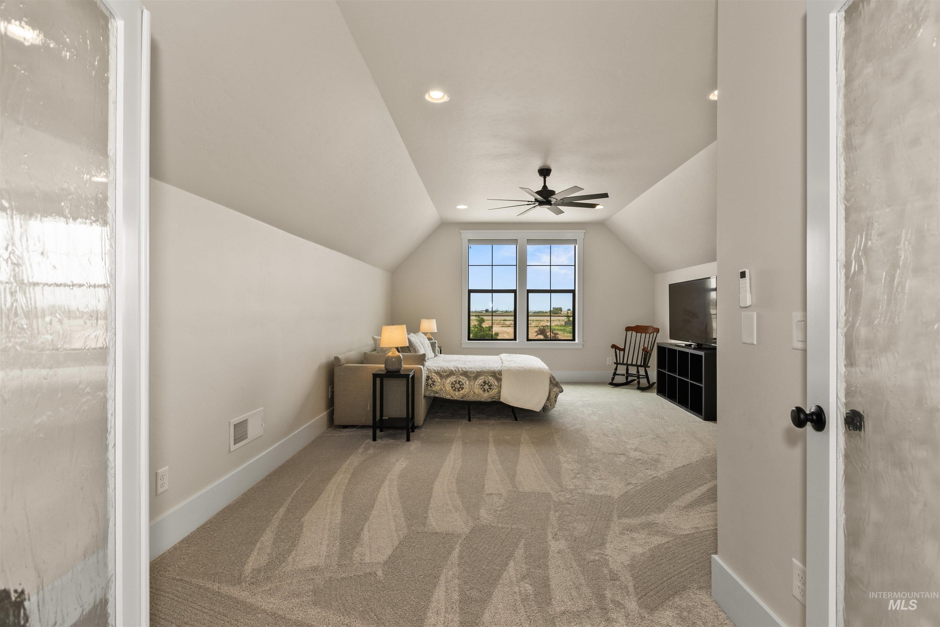 Carpeted bedroom with vaulted ceiling, ceiling fan, and recessed lighting