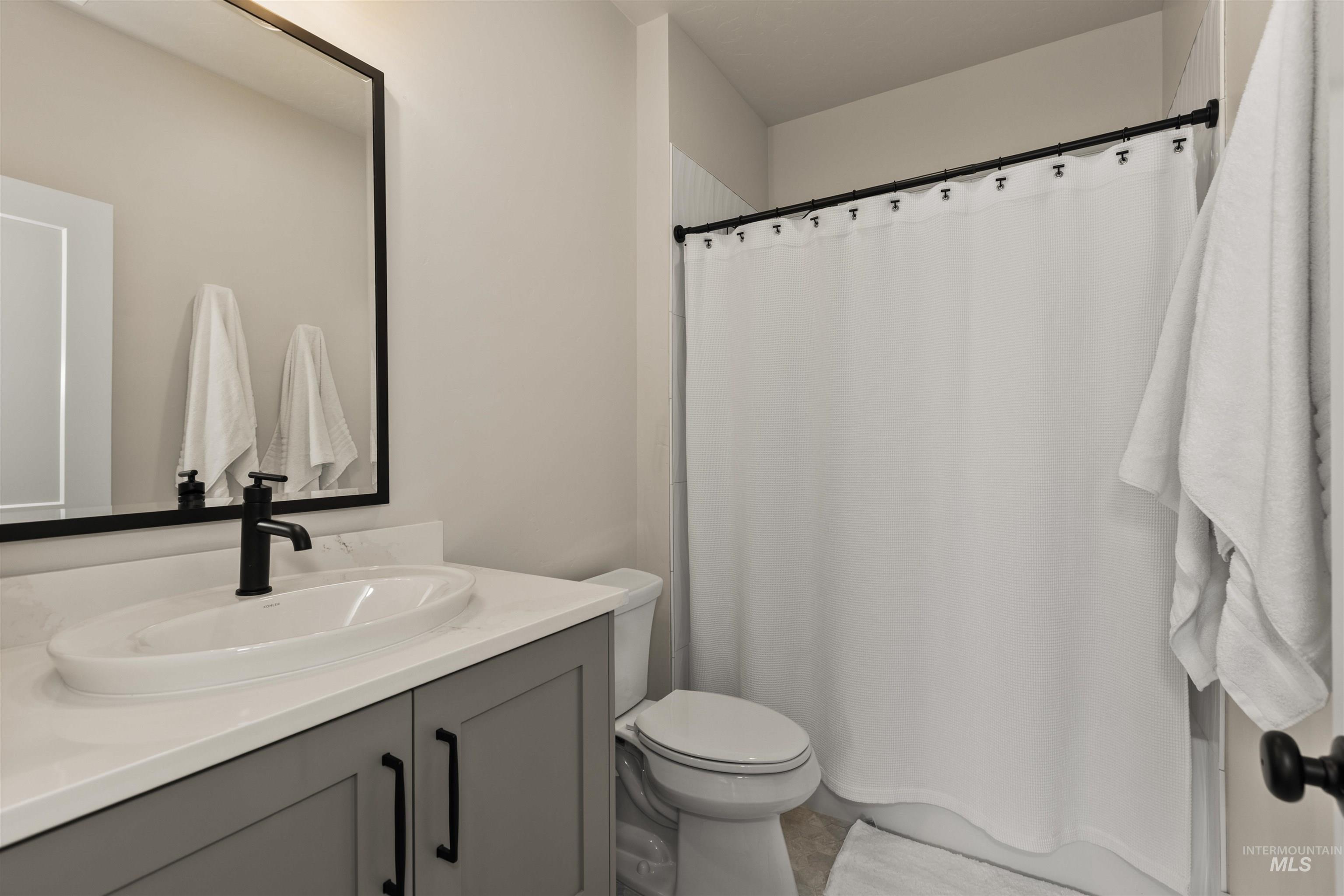 Full bath with vanity and a shower with curtain