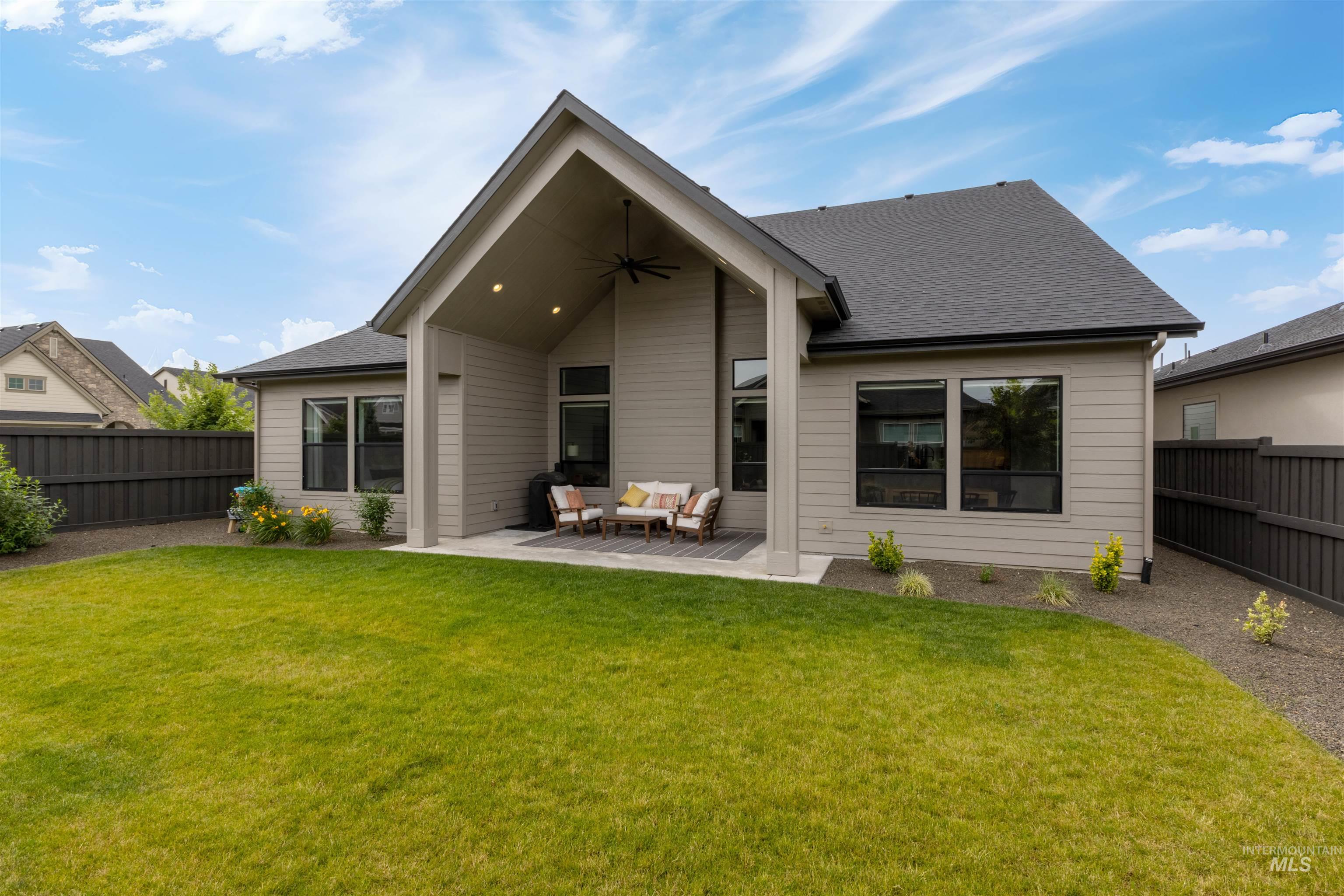 Back of property with outdoor lounge area, a ceiling fan, a fenced backyard, a patio area, and a shingled roof