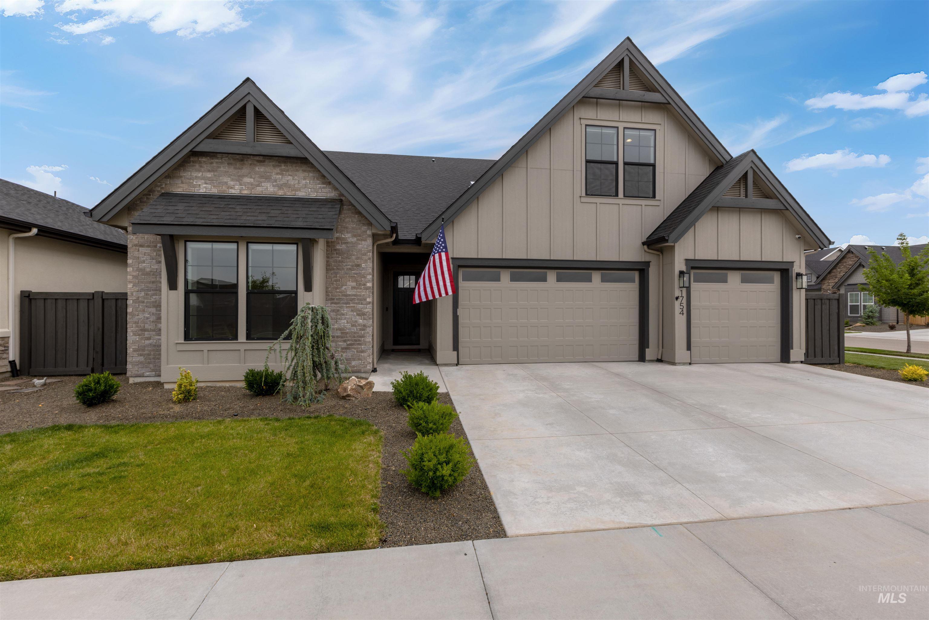 View of front of property with board and batten siding, concrete driveway, a garage, and a shingled roof