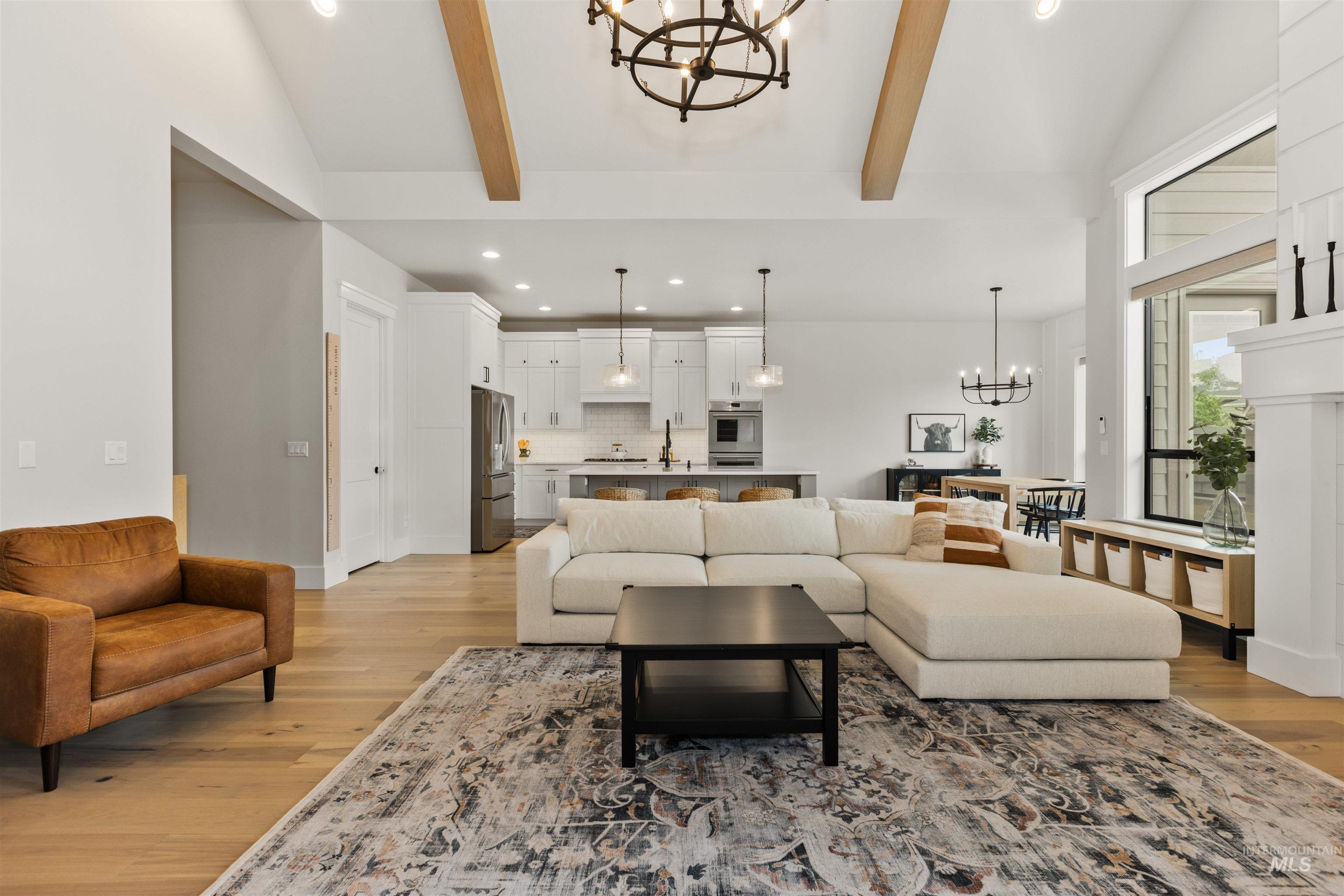 Living room with a chandelier, recessed lighting, and light wood finished floors
