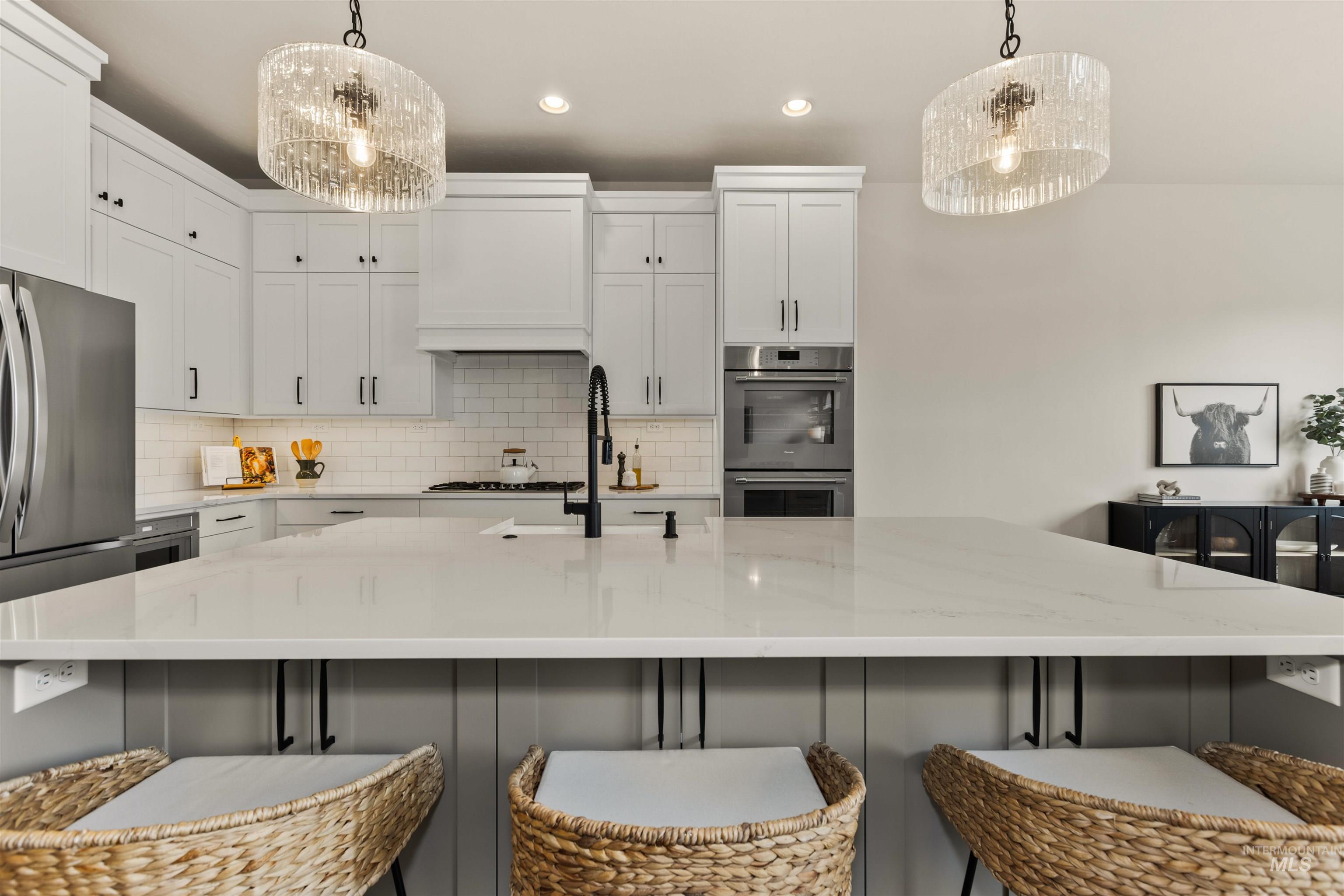 Kitchen featuring appliances with stainless steel finishes, premium range hood, decorative backsplash, white cabinets, and recessed lighting
