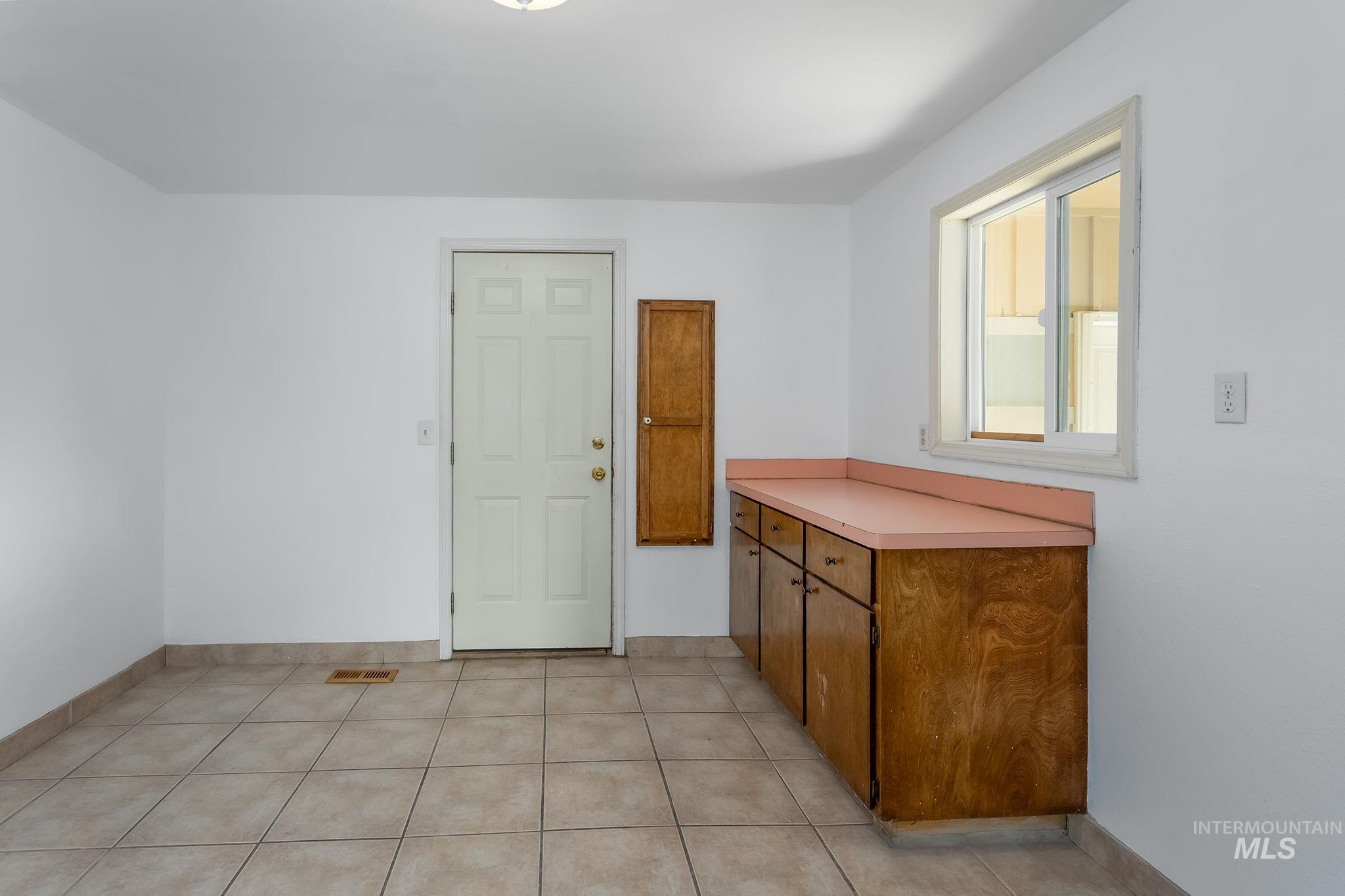 Laundry area featuring baseboards and light tile patterned floors