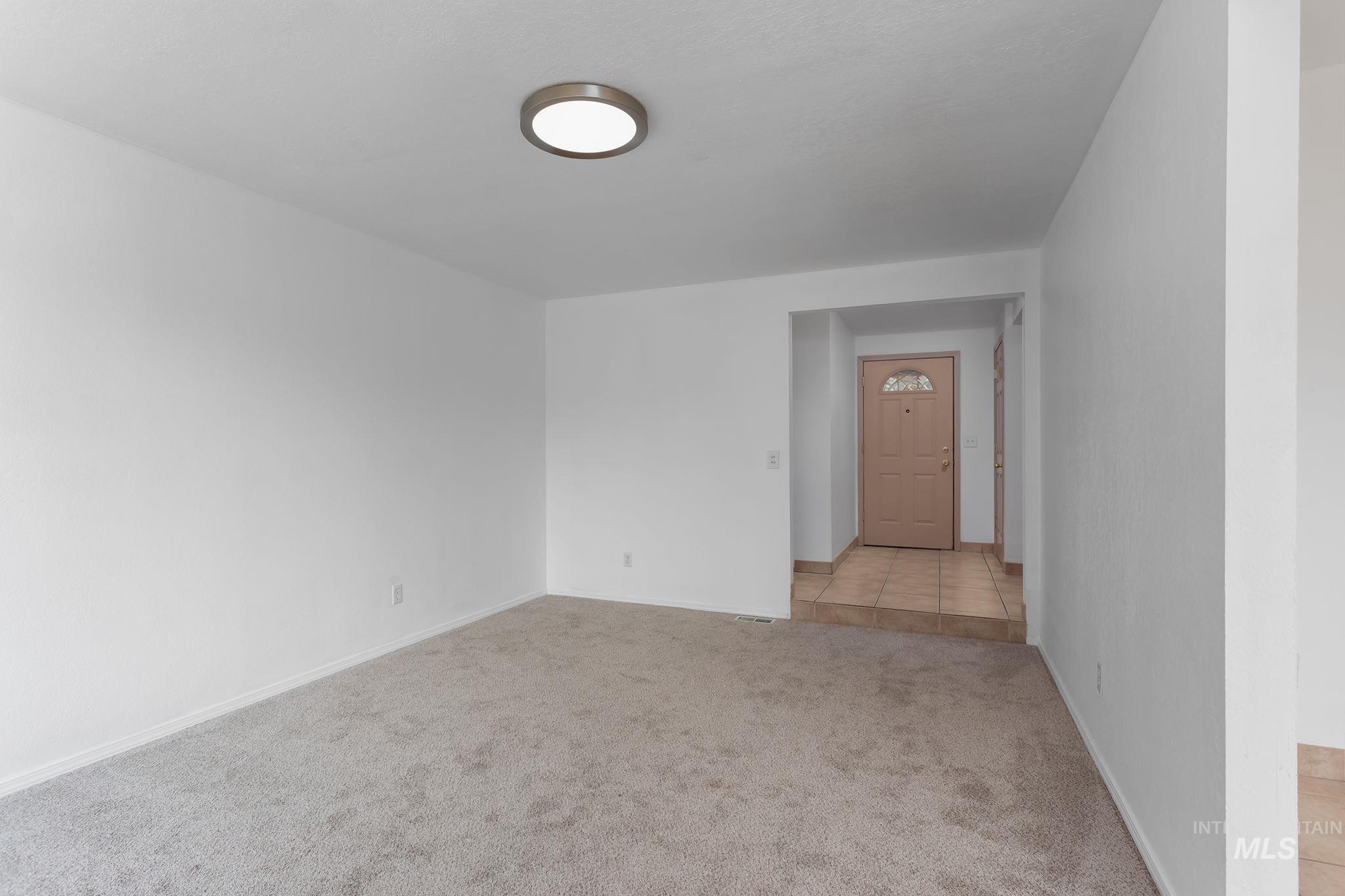 Spare room with light carpet and light tile patterned floors