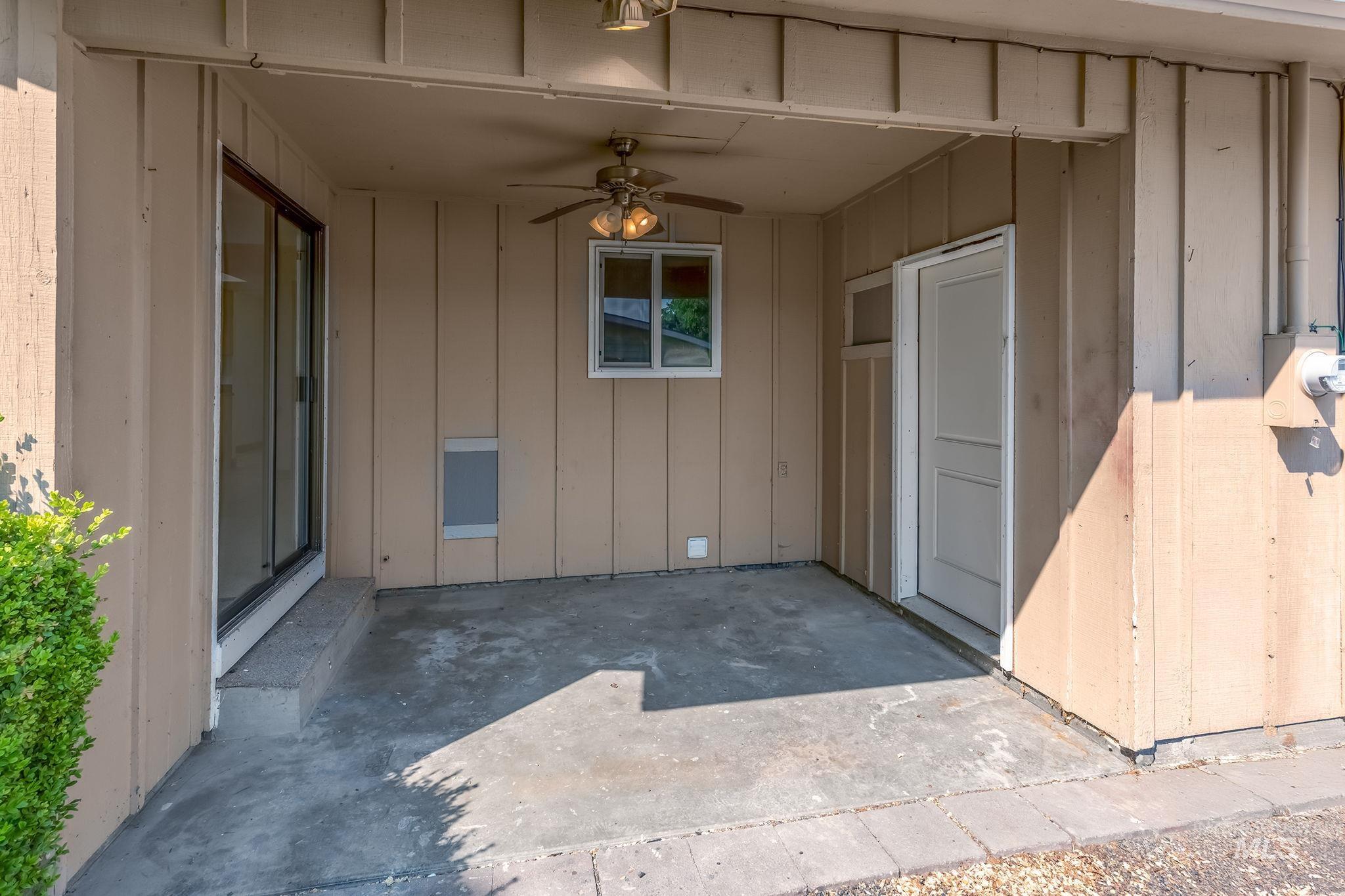 Doorway to property featuring a patio, ceiling fan, and board and batten siding