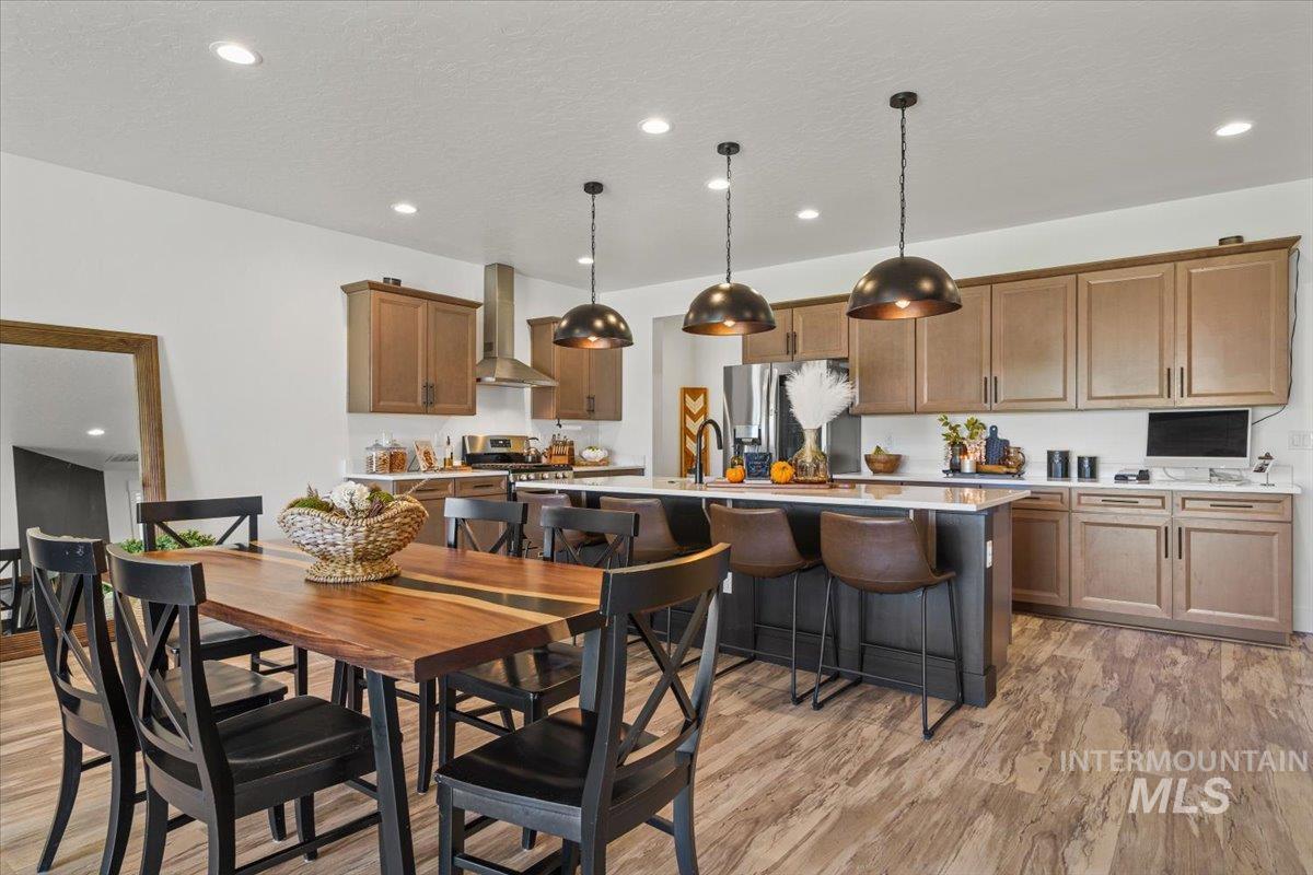 Dining room with recessed lighting, light wood finished floors, and a textured ceiling