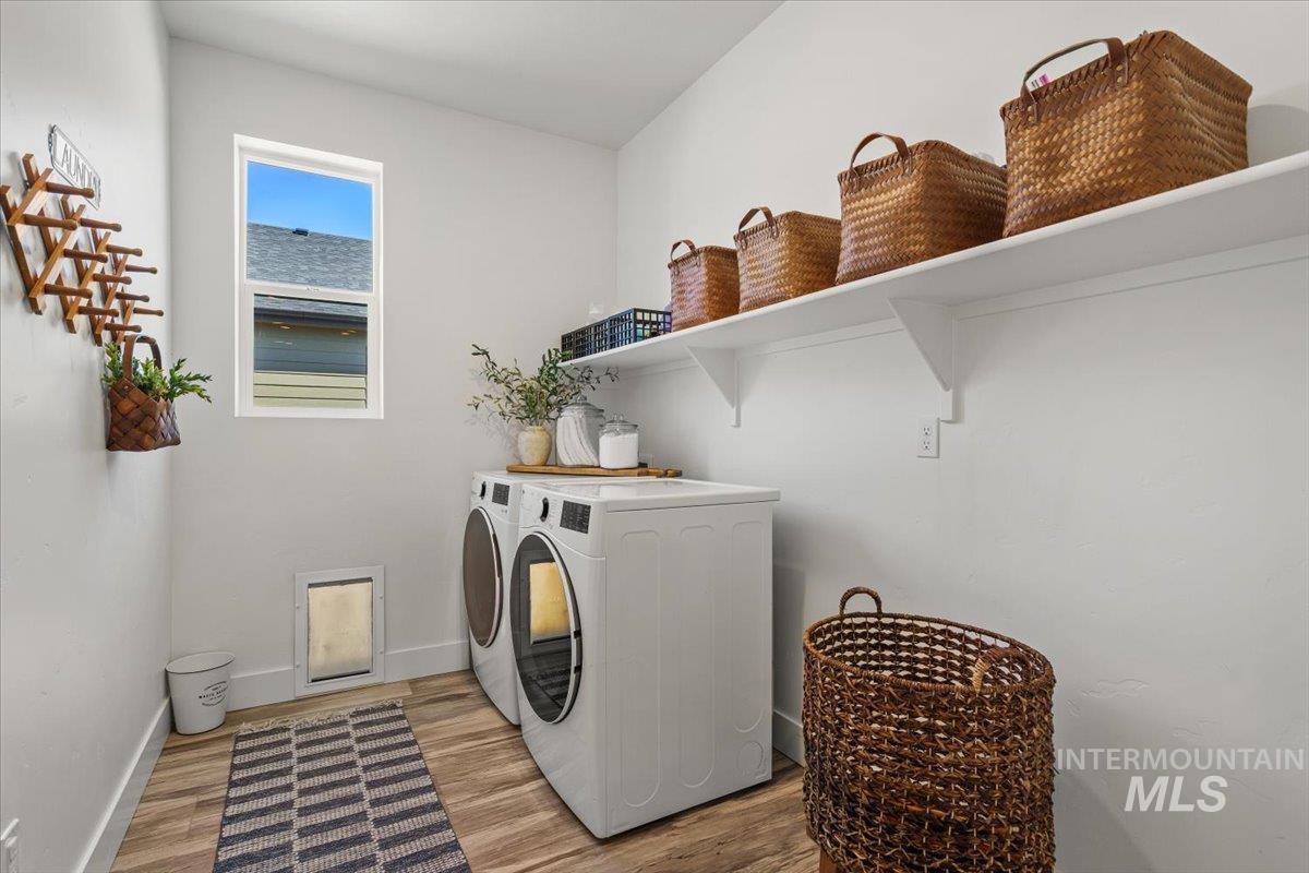 Laundry room with independent washer and dryer and wood finished floors