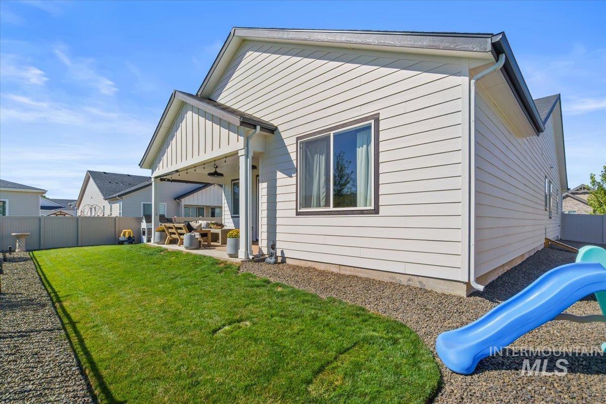Back of property featuring a playground, a patio, an outdoor hangout area, a ceiling fan, and a fenced backyard