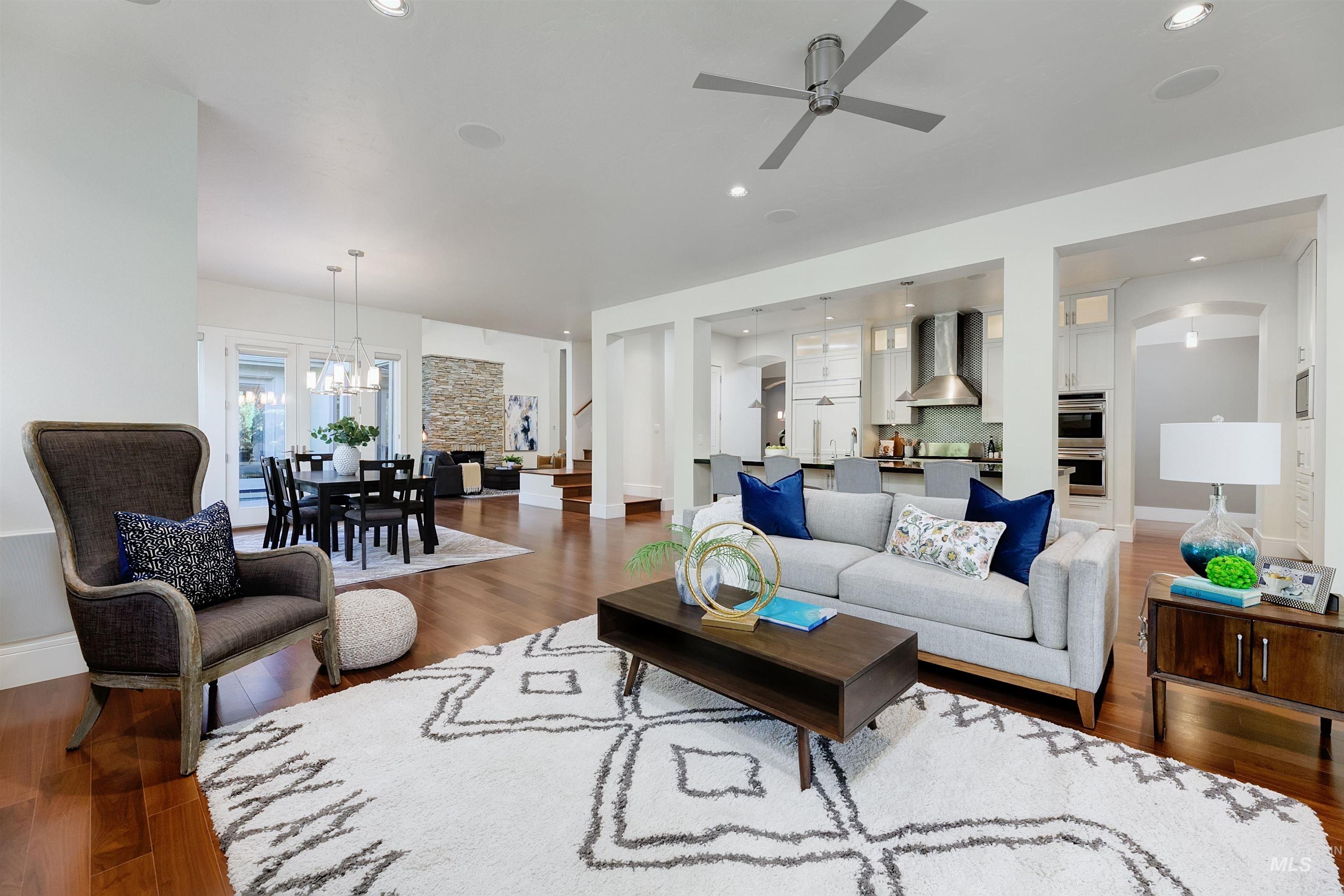 Living area featuring wood finished floors, ceiling fan, recessed lighting, stairway, and a chandelier