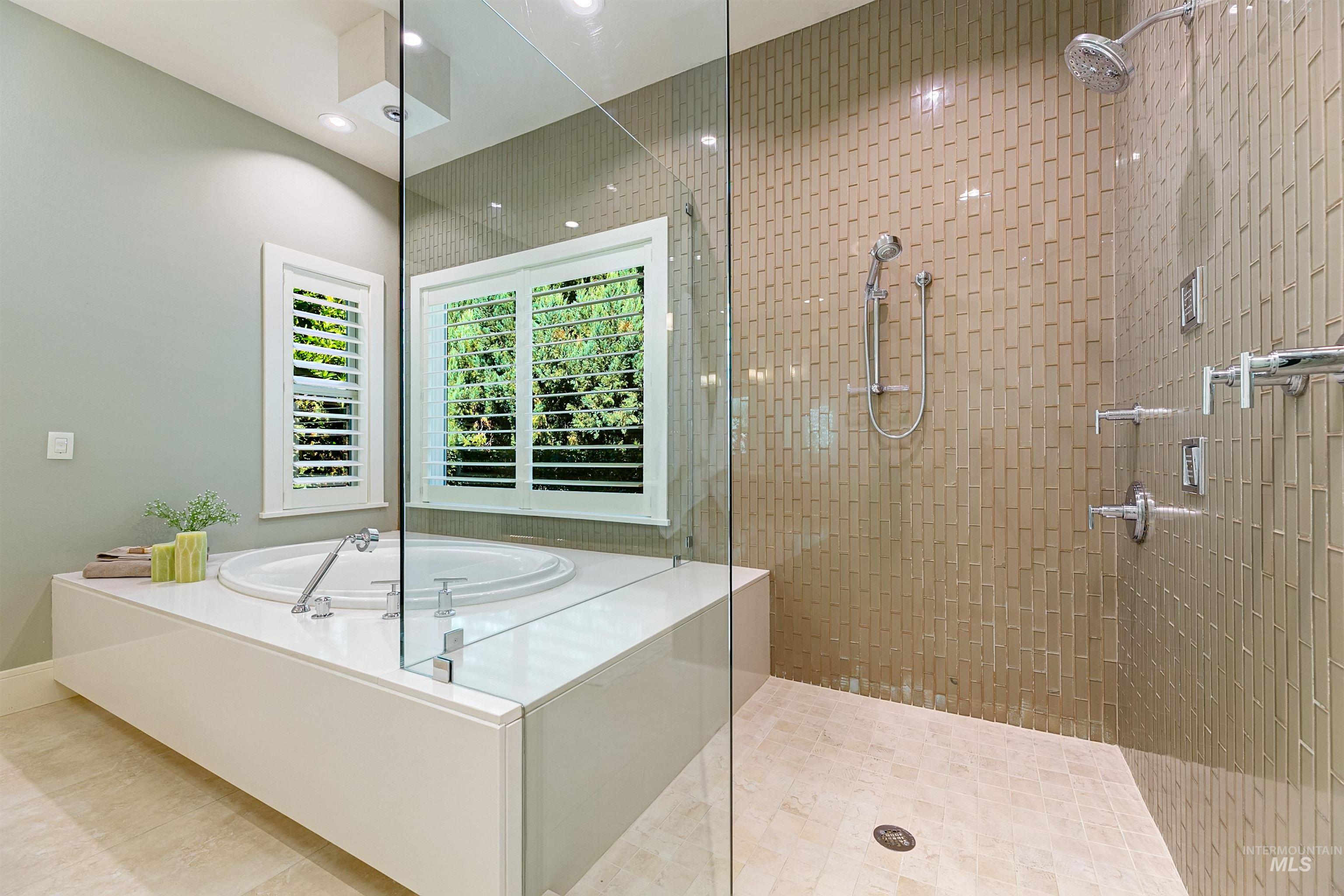 Full bathroom featuring a walk in shower, a bath, recessed lighting, and tile patterned floors
