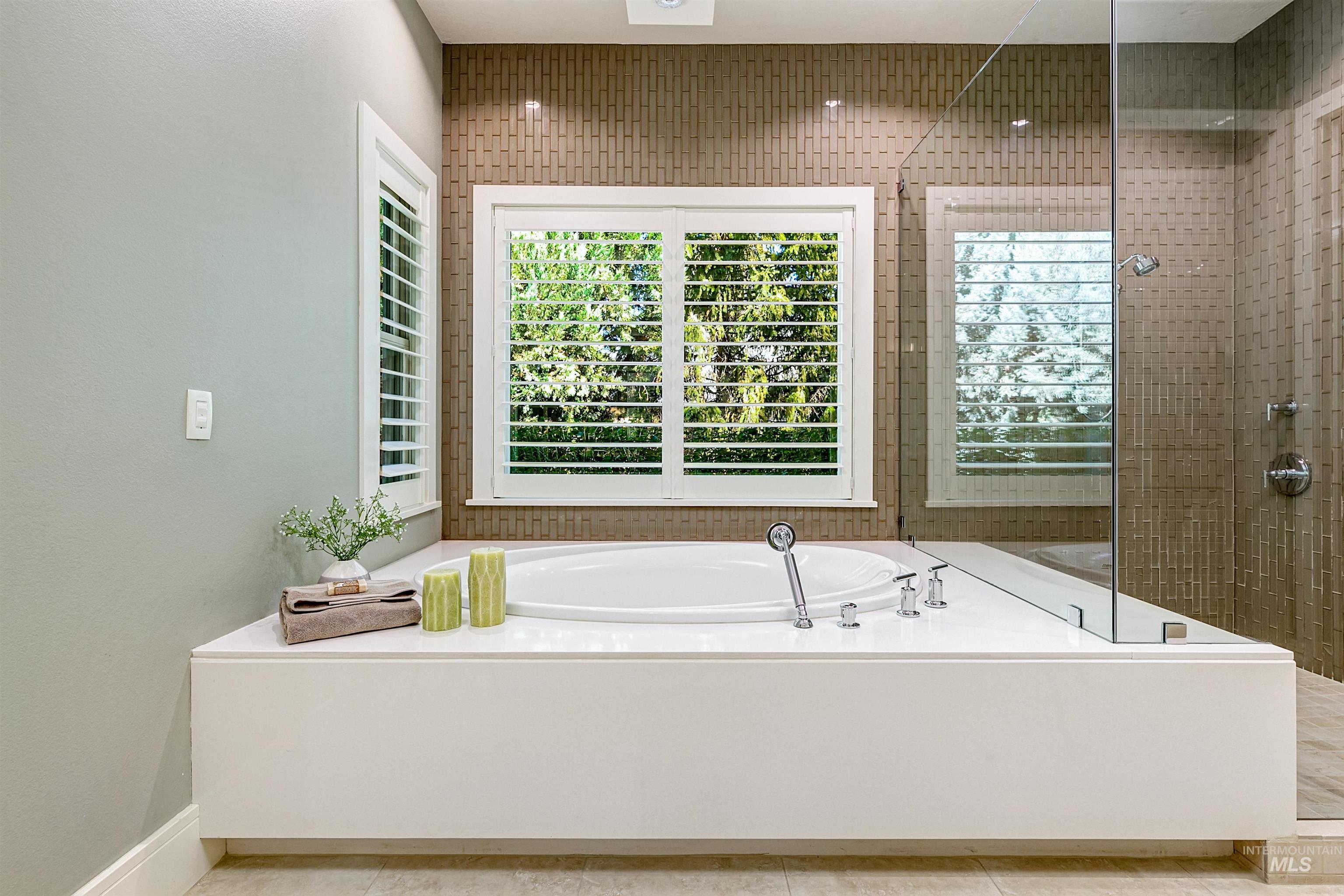 Bathroom featuring a stall shower, a garden tub, and tile patterned floors