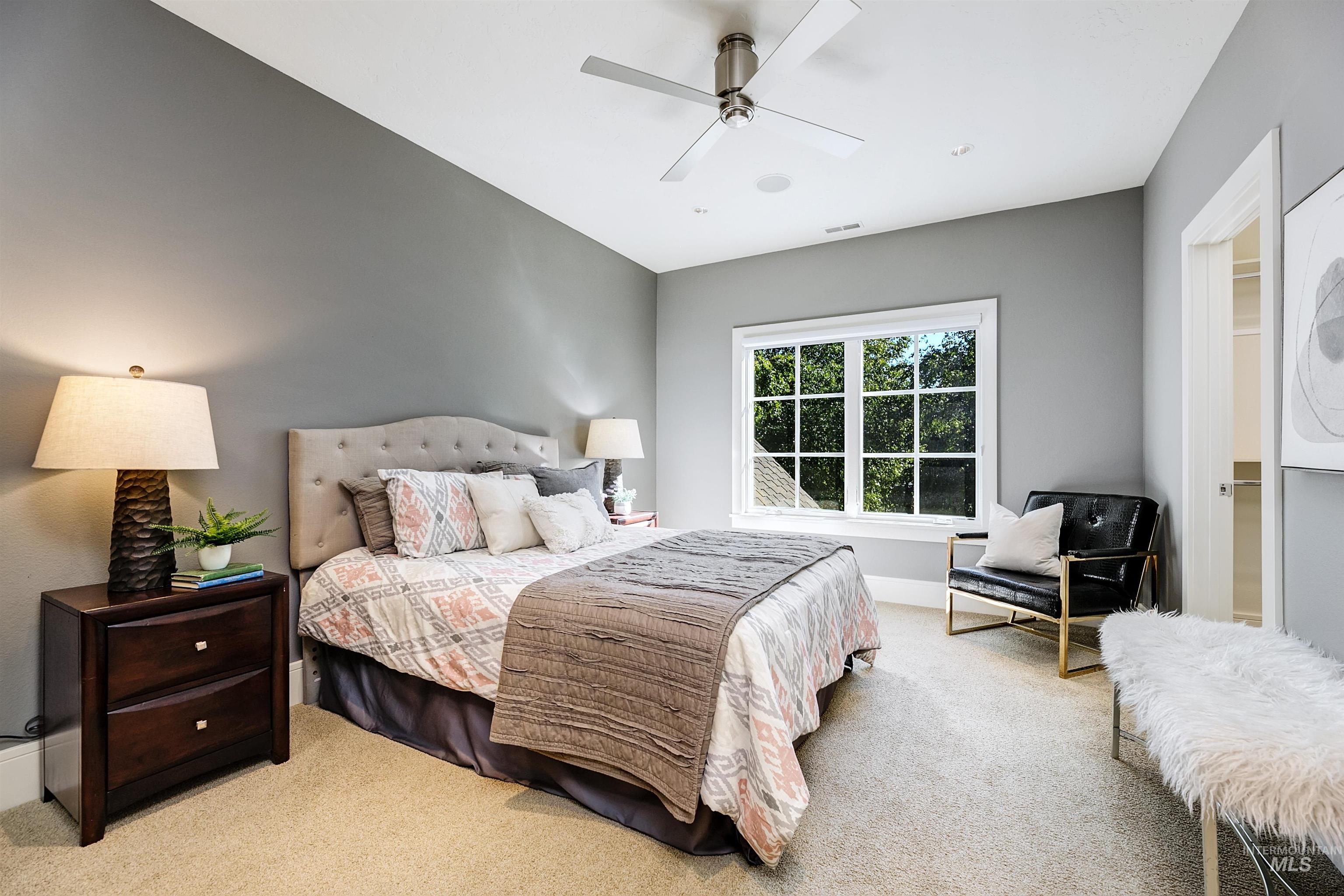 Carpeted bedroom featuring a ceiling fan and baseboards