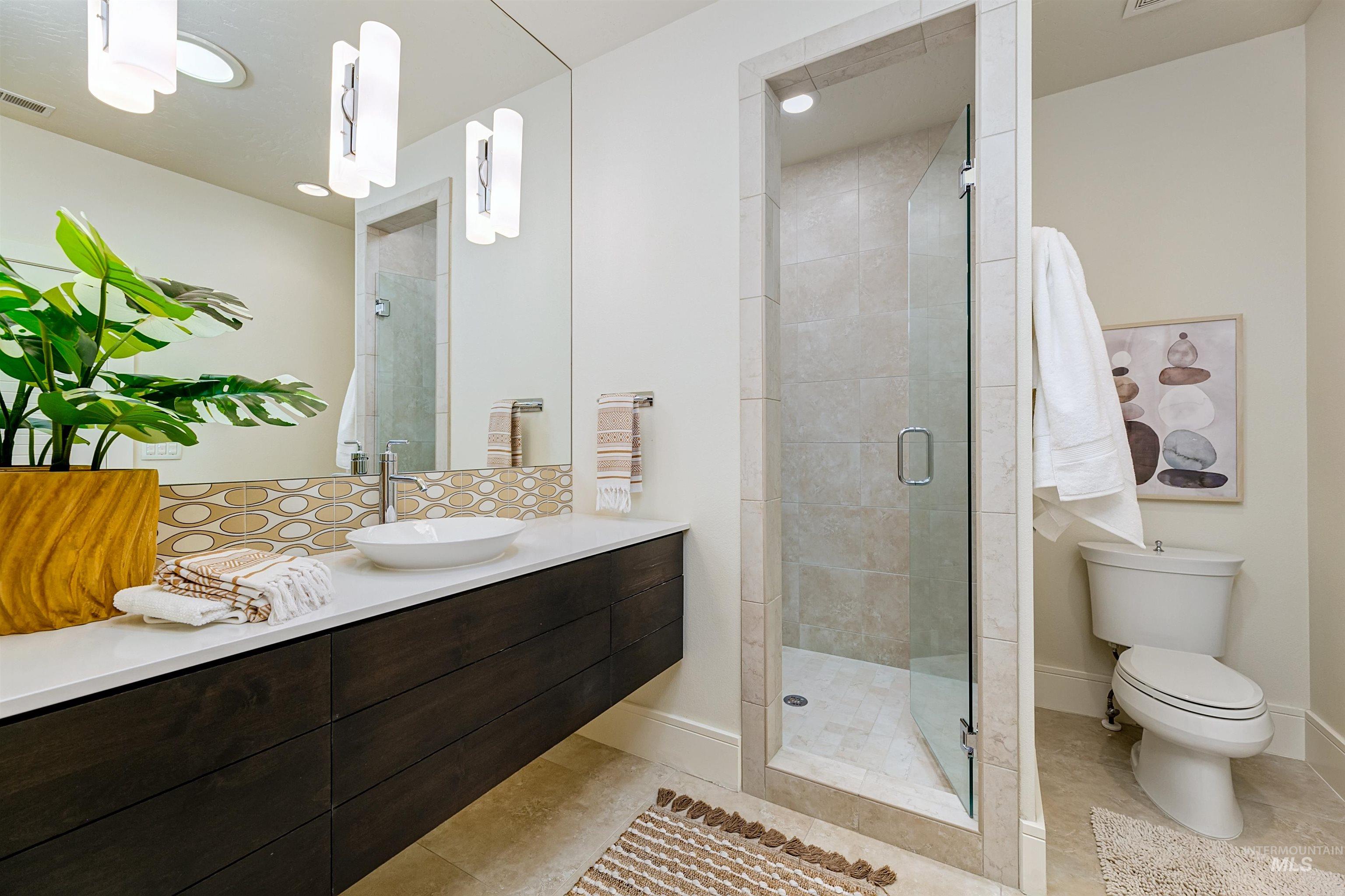 Full bathroom featuring vanity, a shower stall, and light tile patterned floors