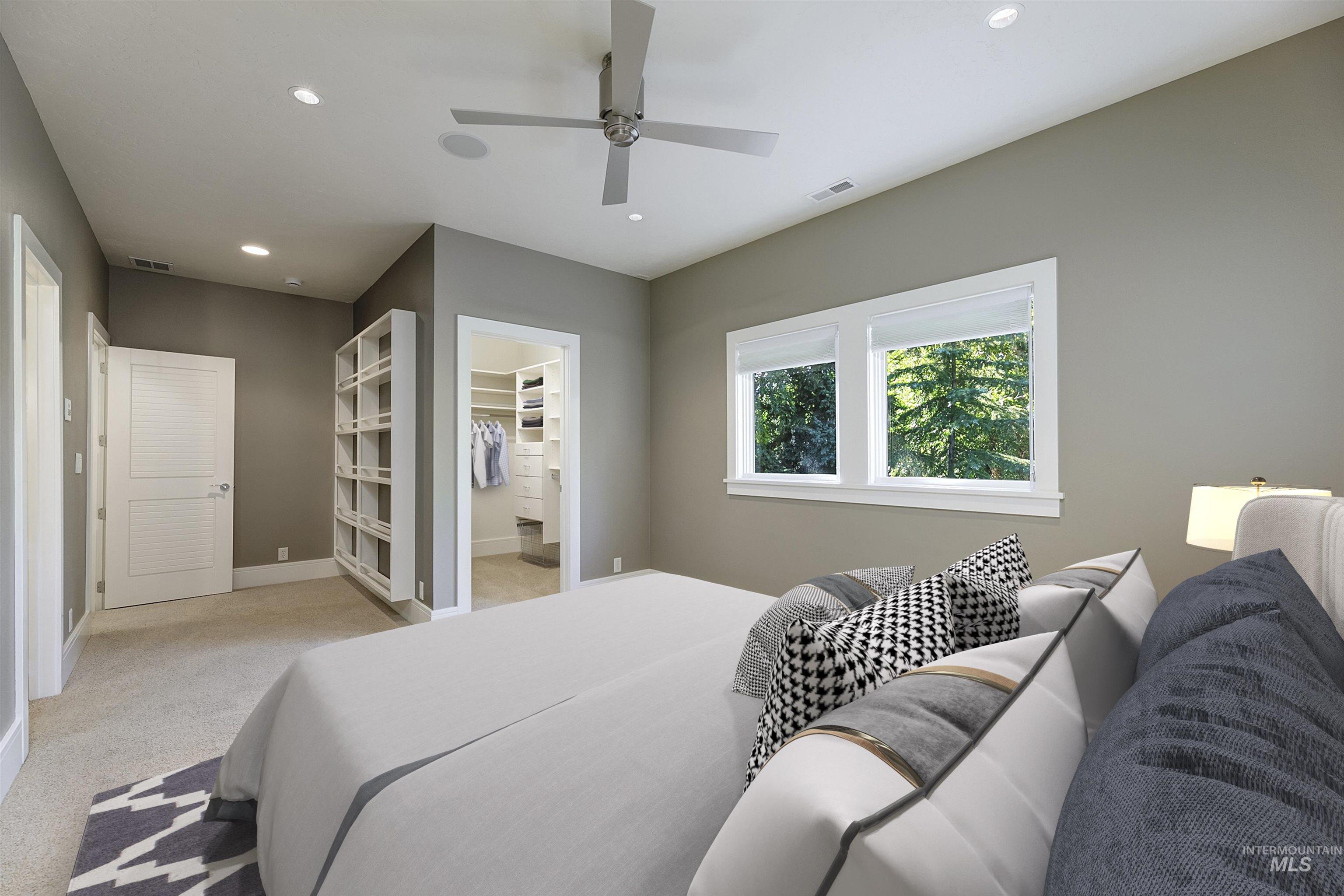 Carpeted bedroom with recessed lighting, a walk in closet, and ceiling fan