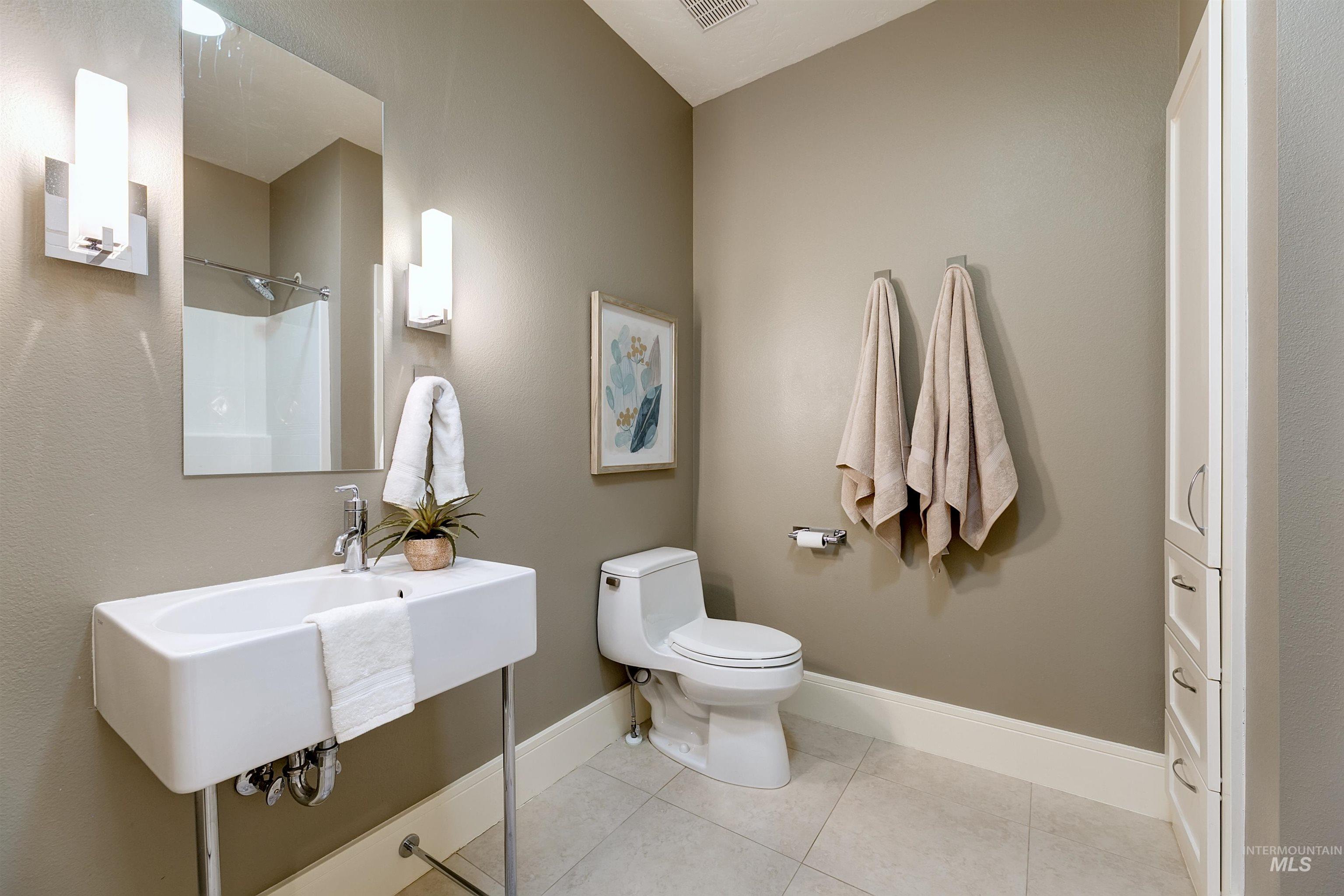 Bathroom with light tile patterned floors and a shower
