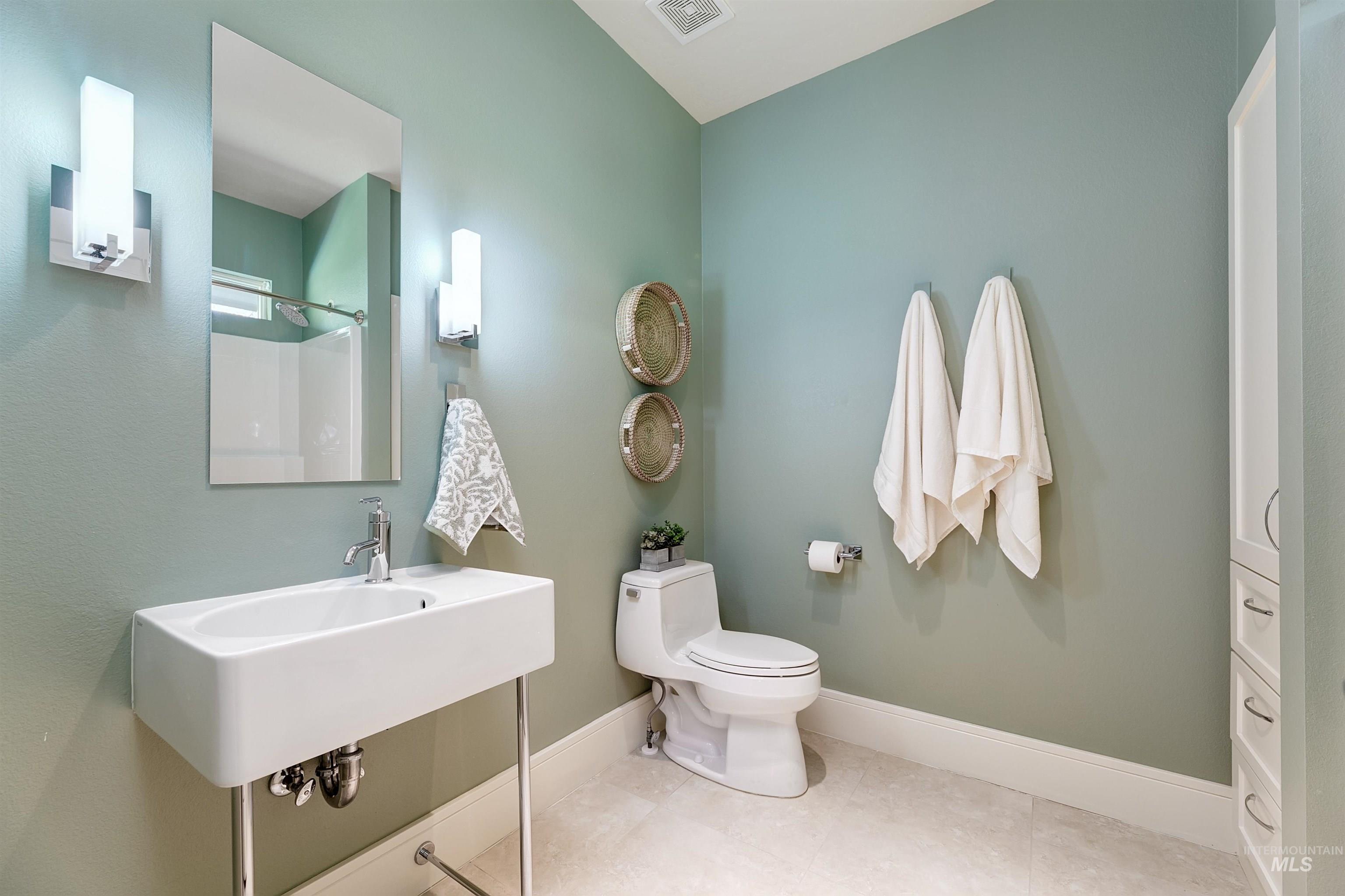 Bathroom with a shower and light tile patterned floors