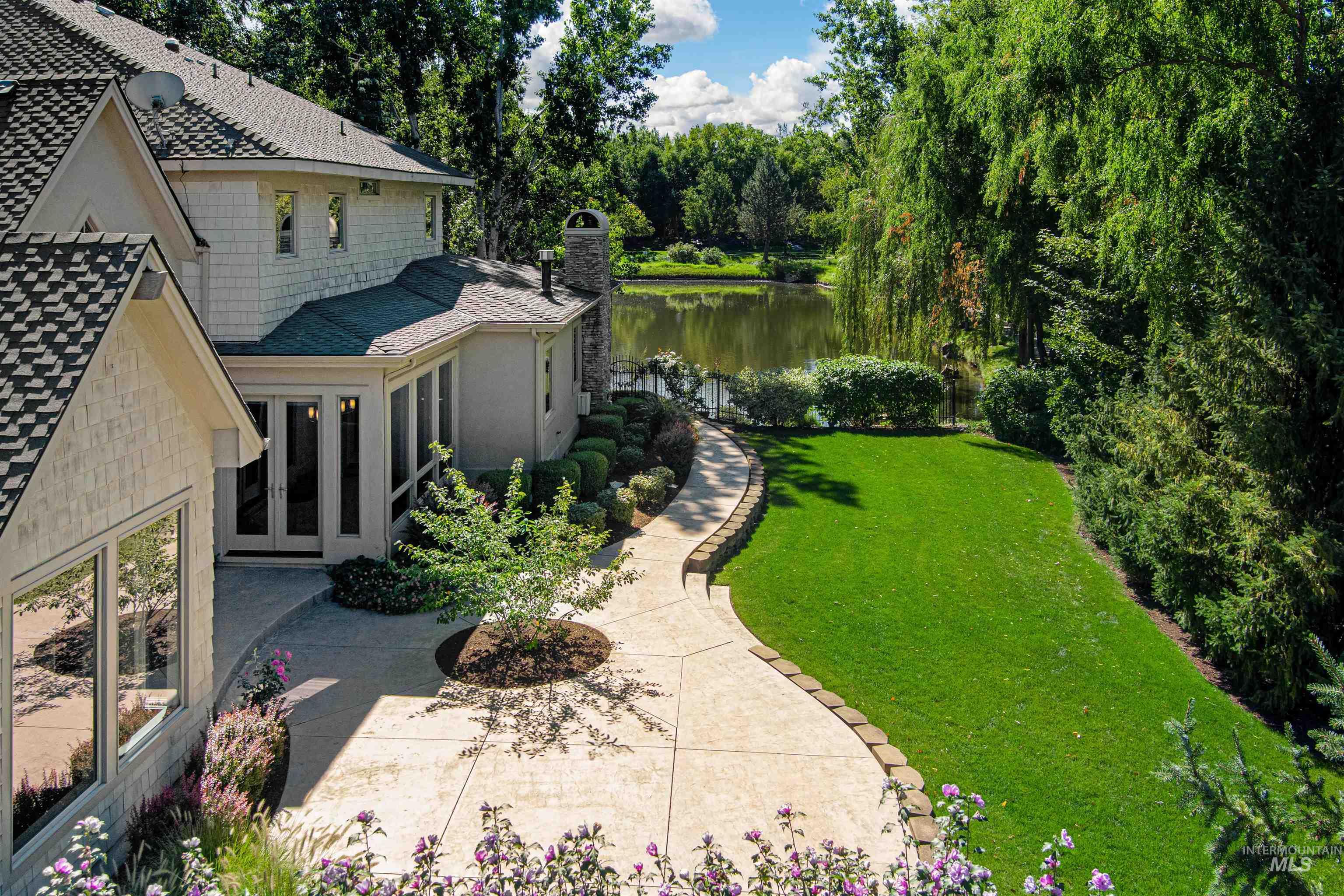 View of grassy yard with a water view and french doors