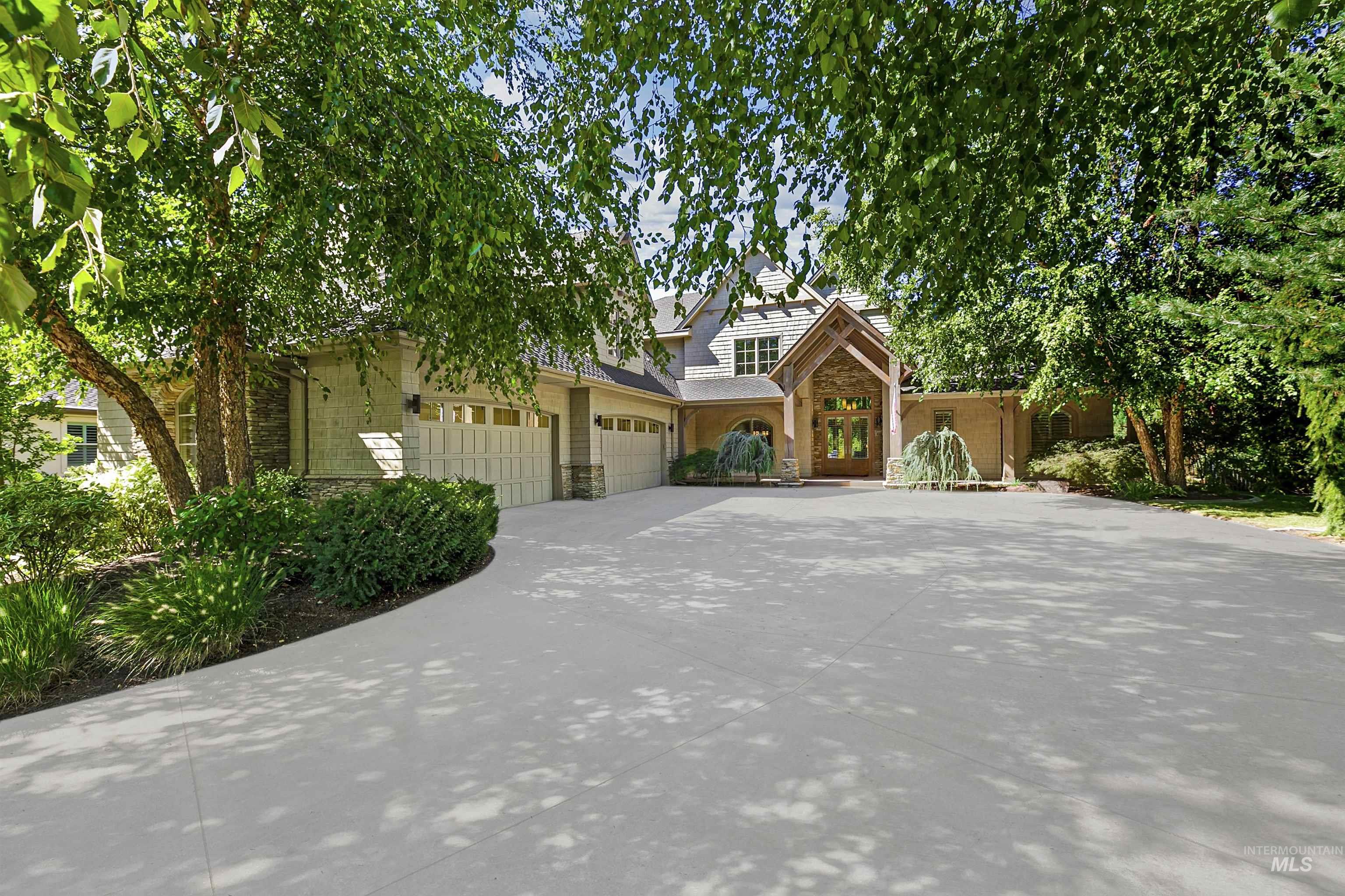 View of front of house with stone siding, concrete driveway, and a garage