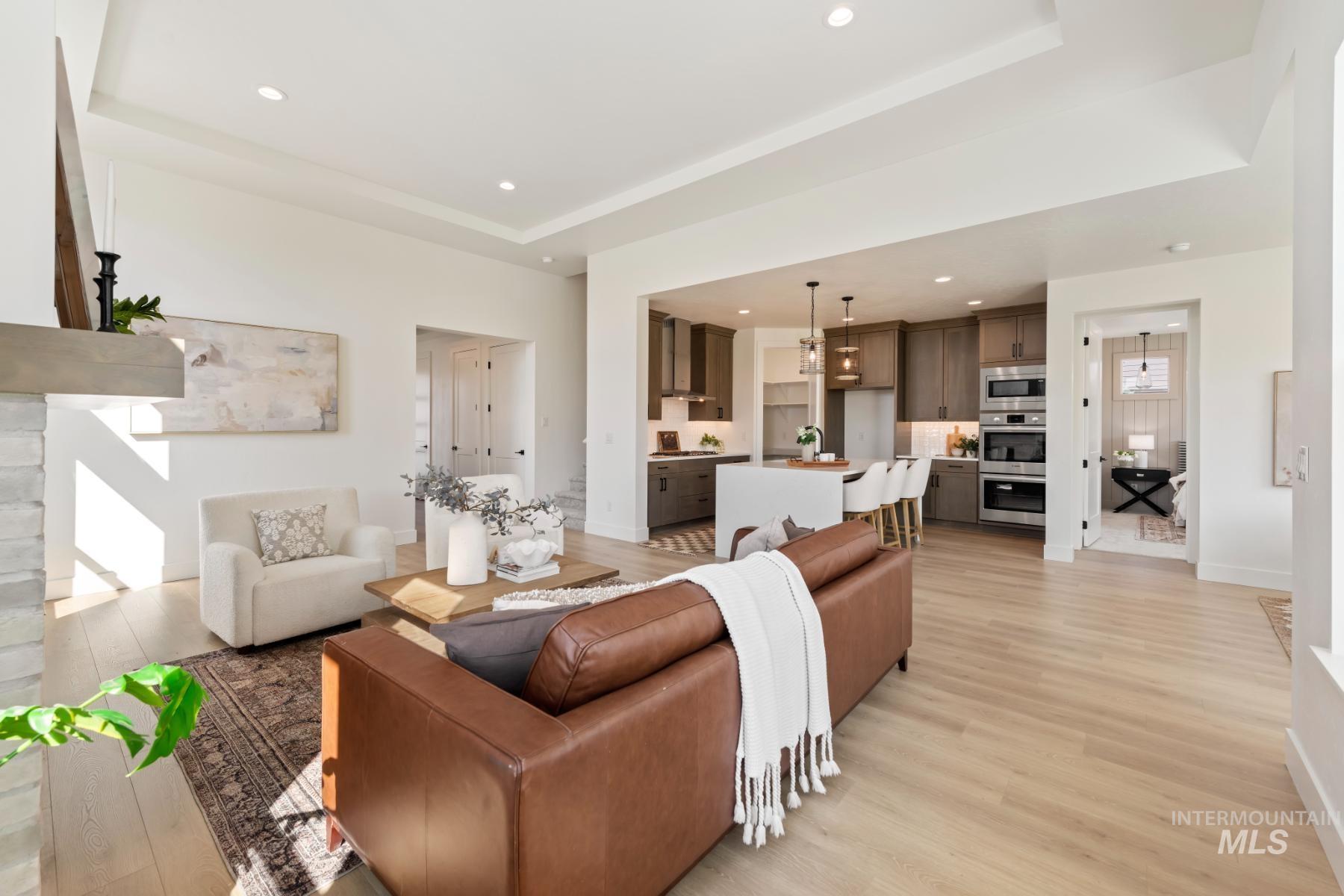 Living room featuring recessed lighting, light wood-style floors, and a tray ceiling