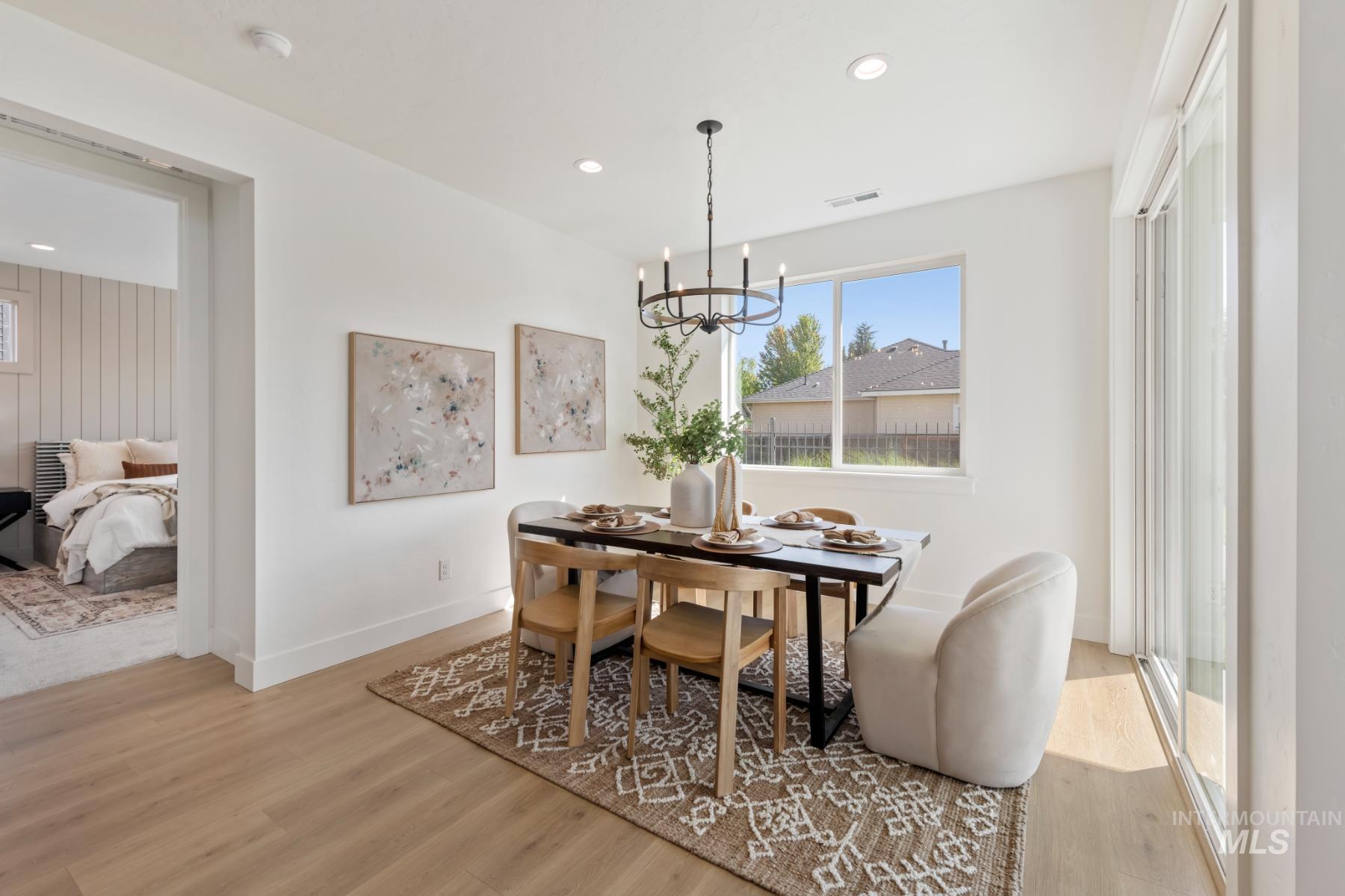Dining area with plenty of natural light, light wood-style flooring, a chandelier, and recessed lighting
