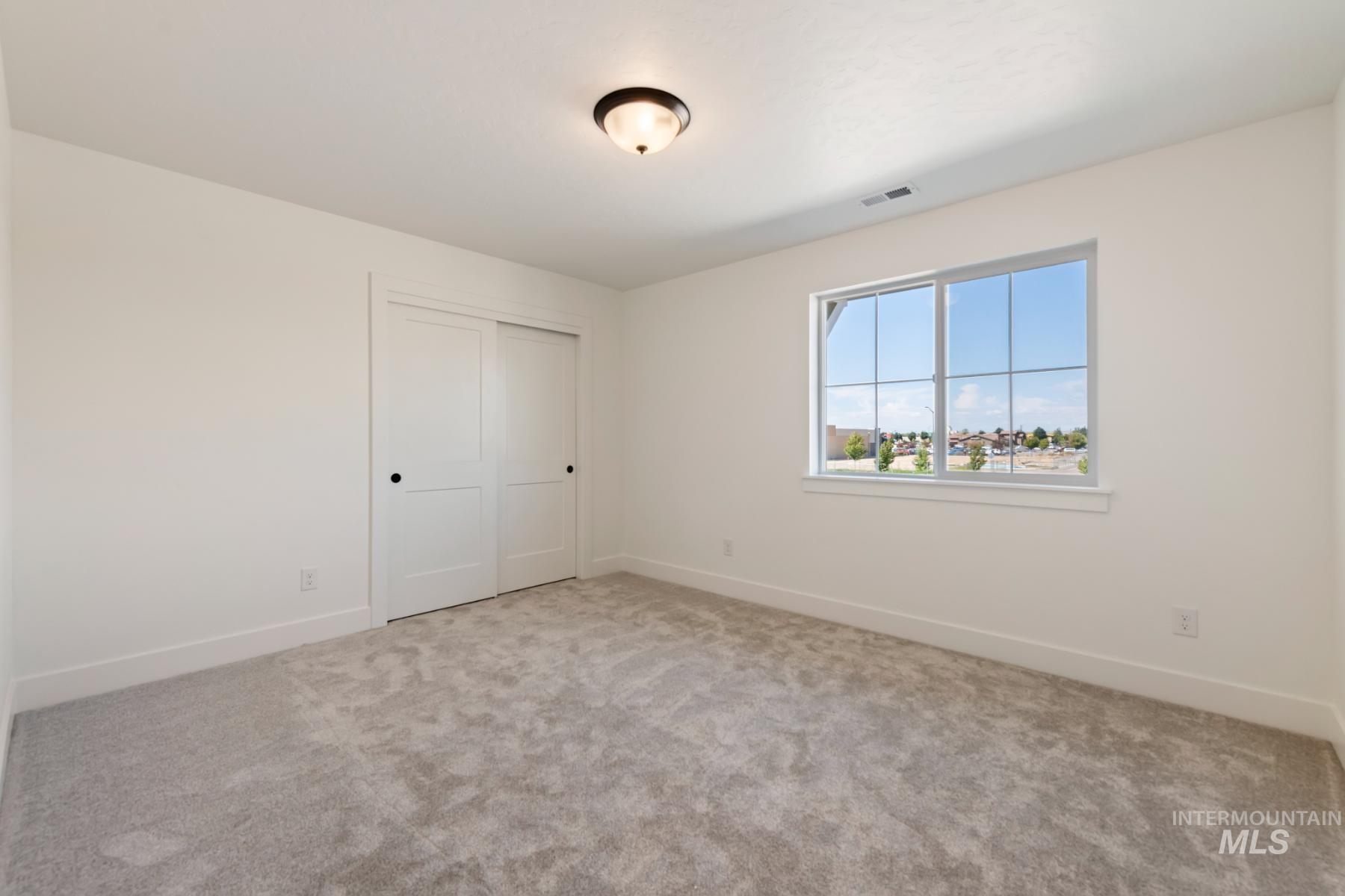 Unfurnished bedroom featuring a closet and light carpet