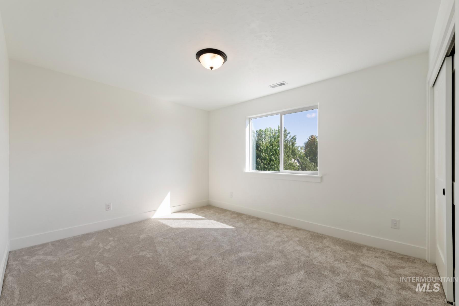 Unfurnished bedroom with light colored carpet and a closet