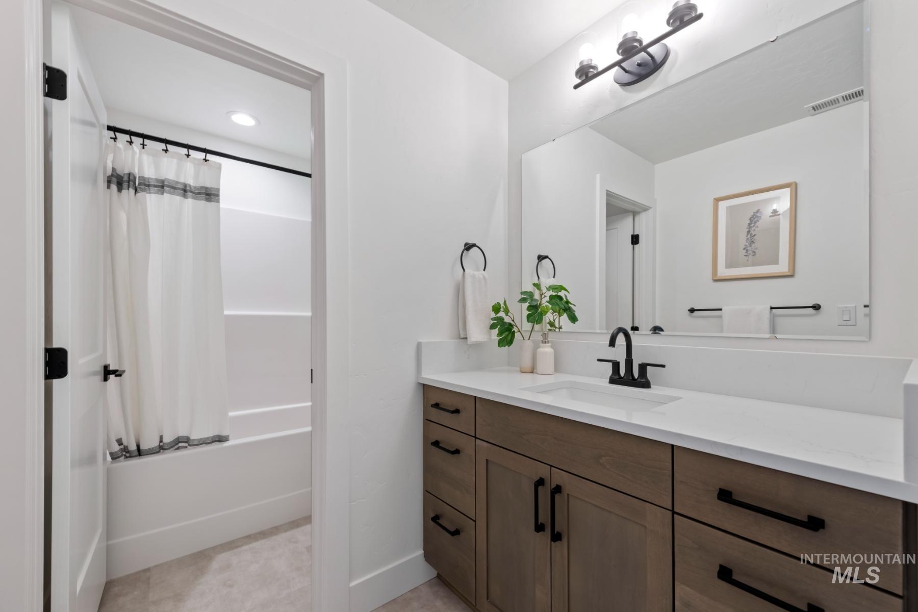 Full bath featuring shower / bath combo and vanity