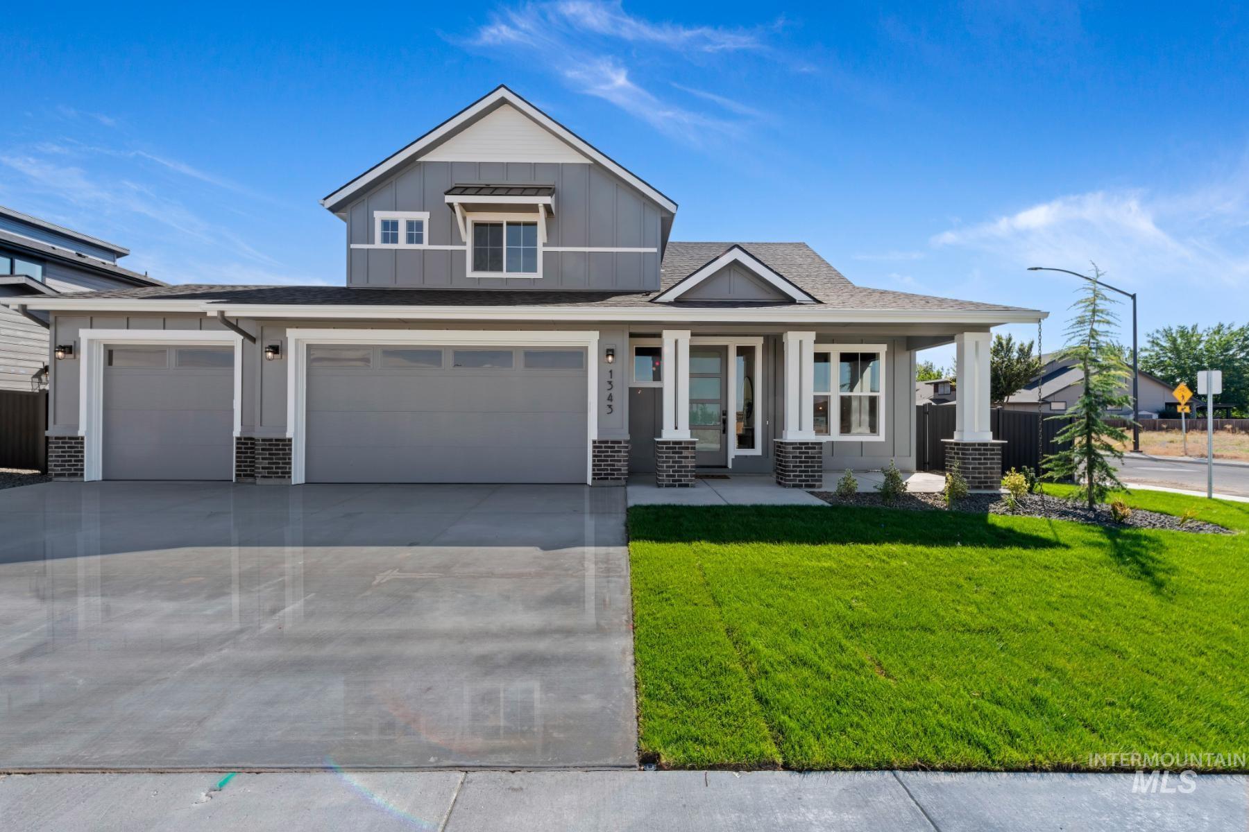 Craftsman-style house with board and batten siding, brick siding, covered porch, concrete driveway, and a shingled roof