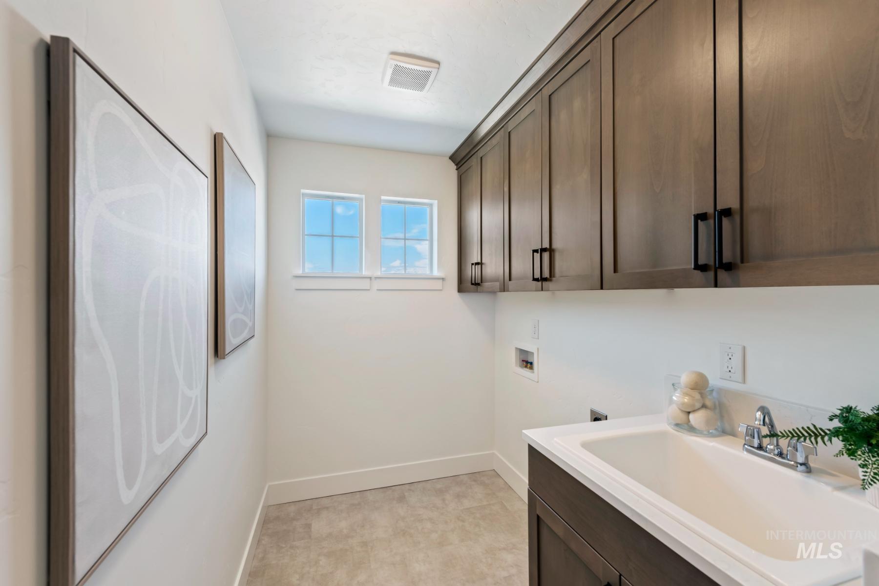 Washroom featuring washer hookup and cabinet space