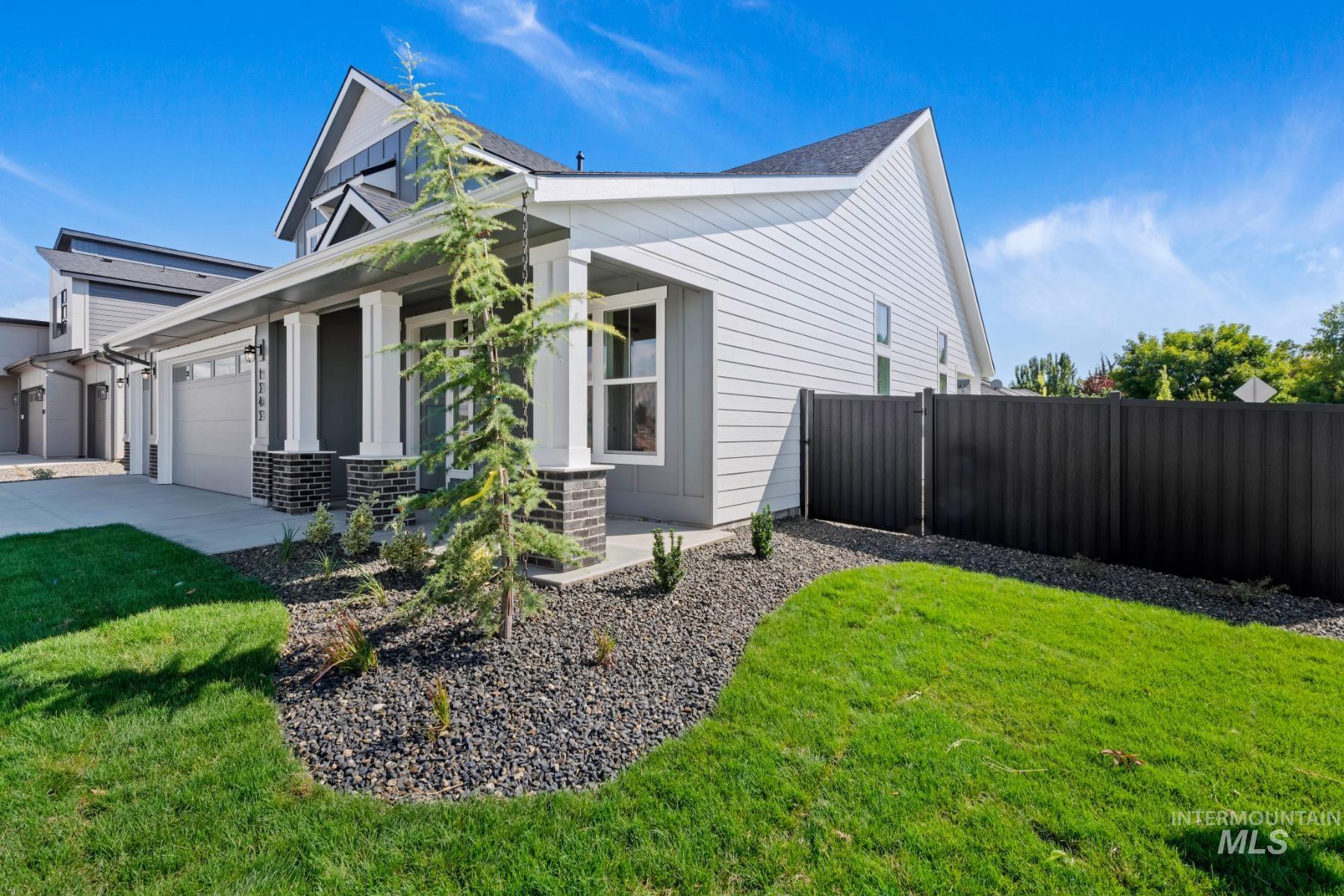 View of side of property with covered porch, an attached garage, and driveway