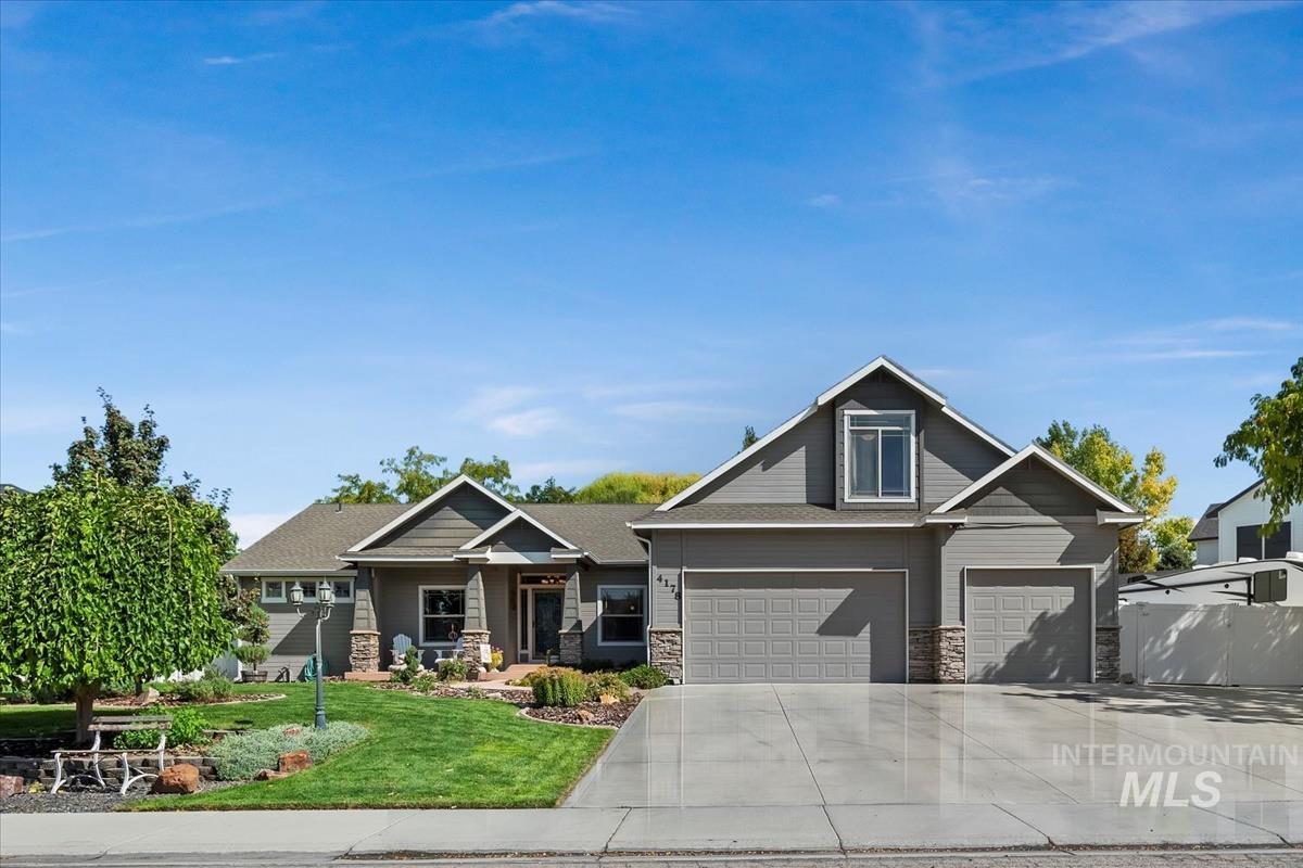Craftsman house featuring driveway, a front lawn, stone siding, and a porch