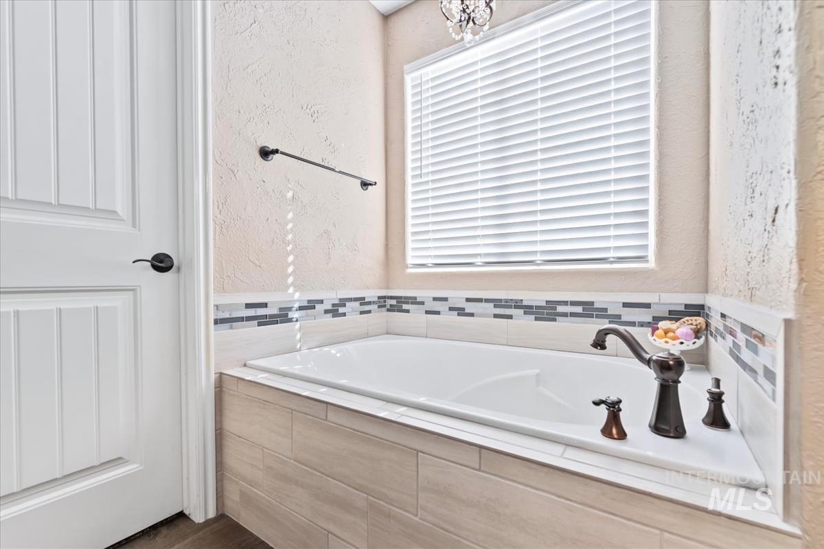 Bathroom with a textured wall and a garden tub
